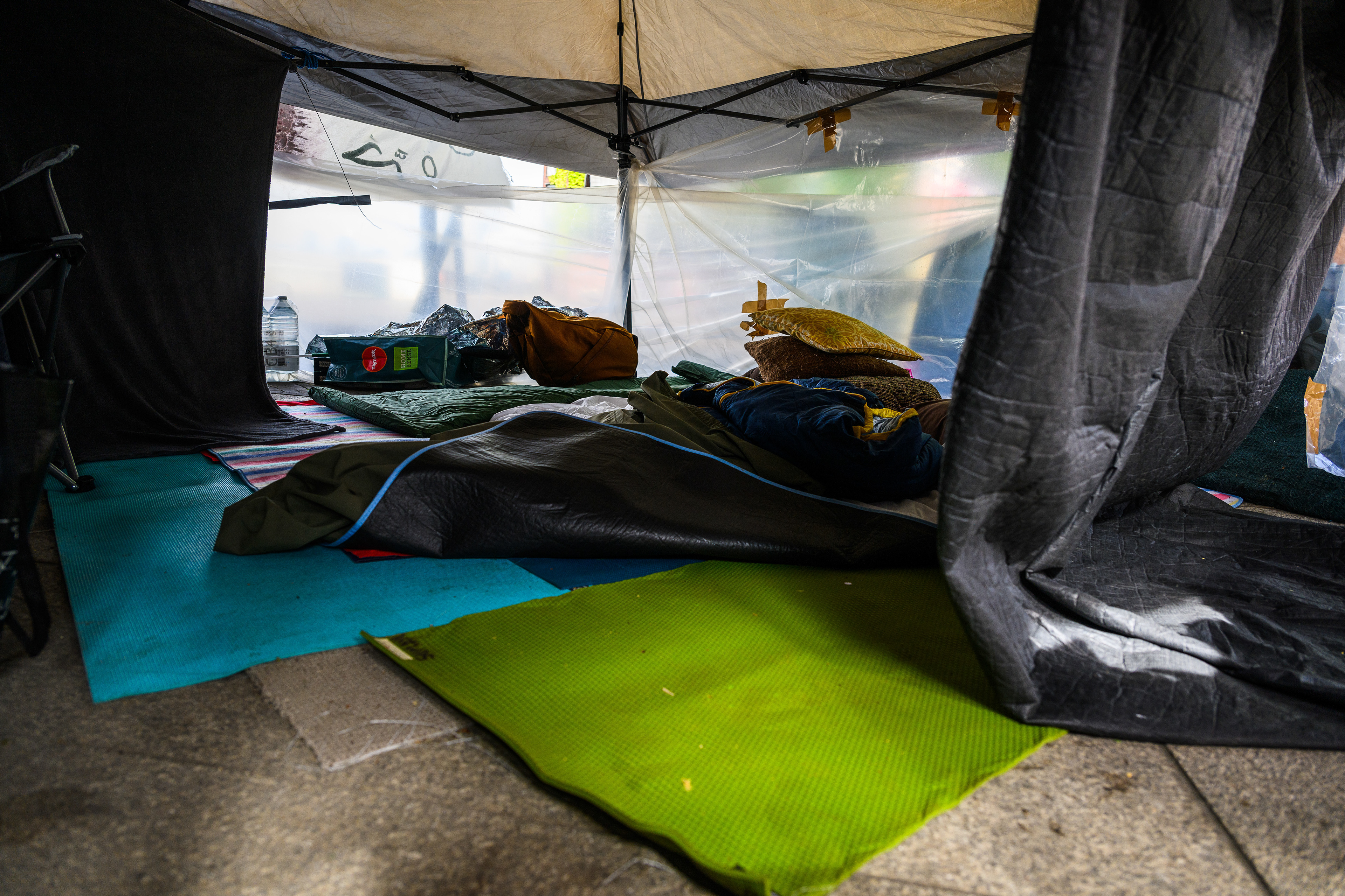 The sleeping area is a tent with some floors mats and sleeping bags. Protesters stay here at night to keep the camp safe outside the US Embassy