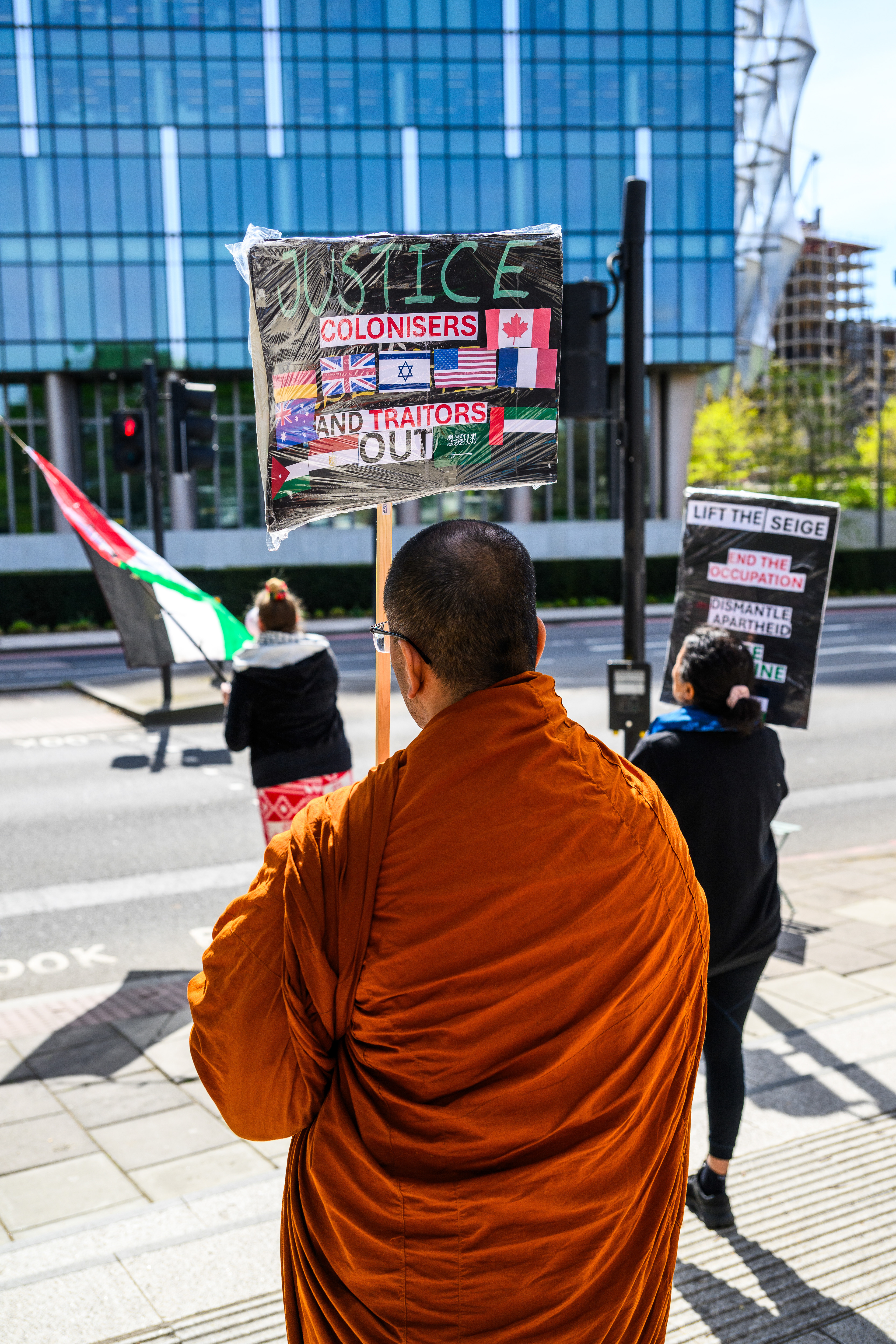 The protesters stand by the roadside outside the US Embassy to wave the Palestine flag and encourage support from drivers