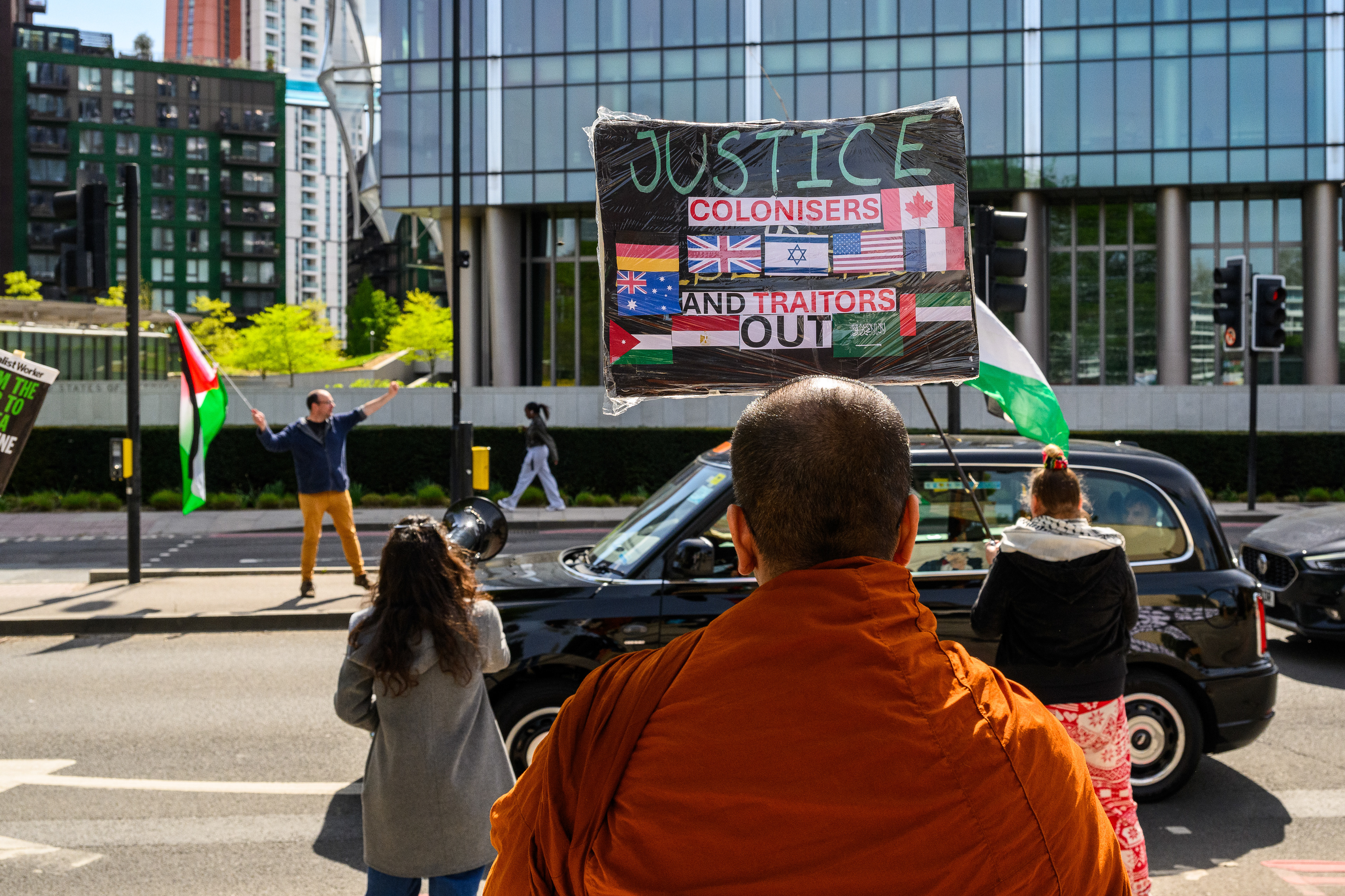 The protesters stand by the roadside outside the US Embassy to wave the Palestine flag and encourage support from drivers