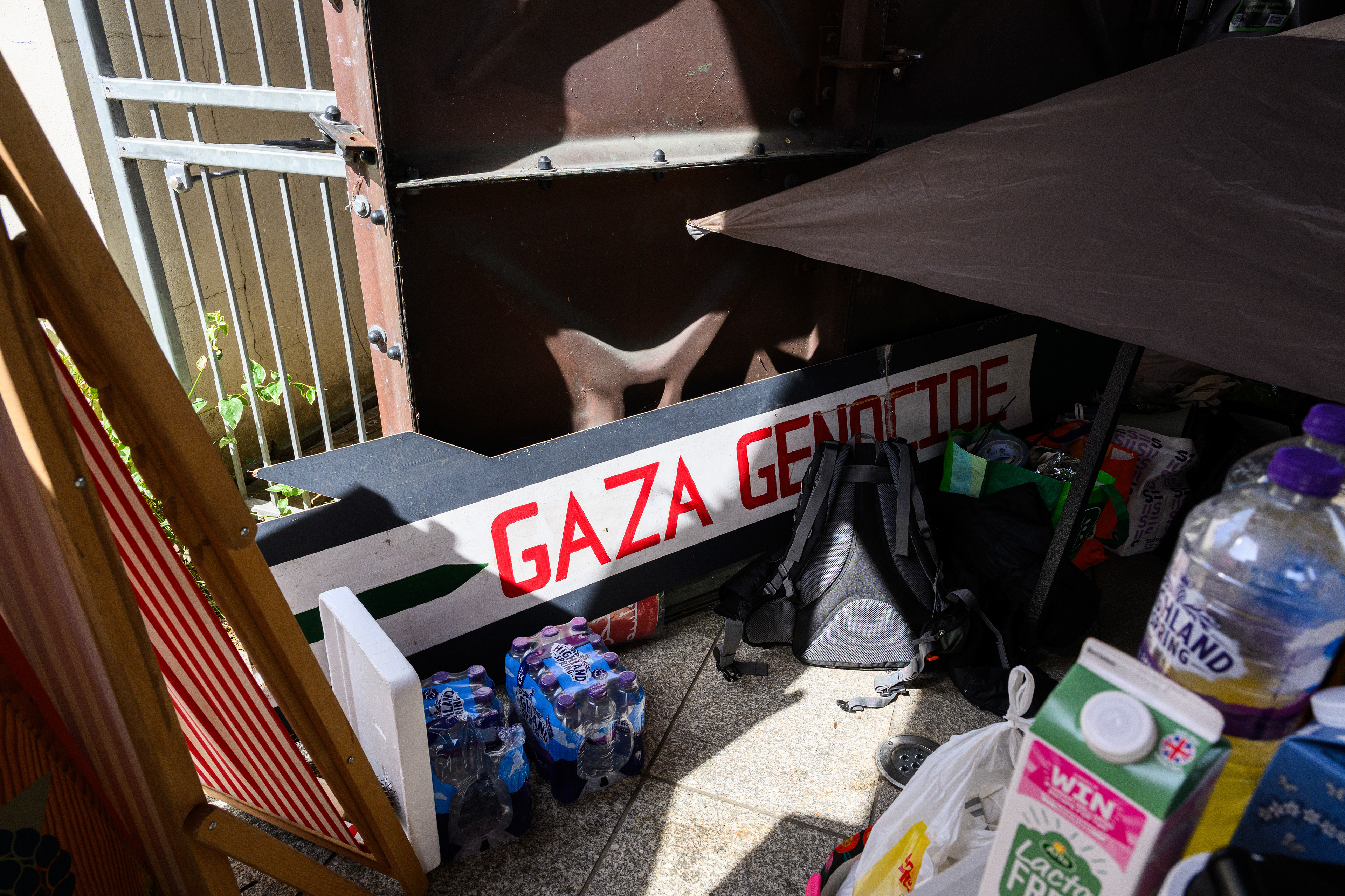 The camps communal kitchen is stocked with plenty of donated water bottles and a sign that reads "Gaza genocide."