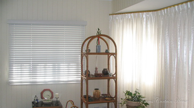 Venetians beside curtain in bay window