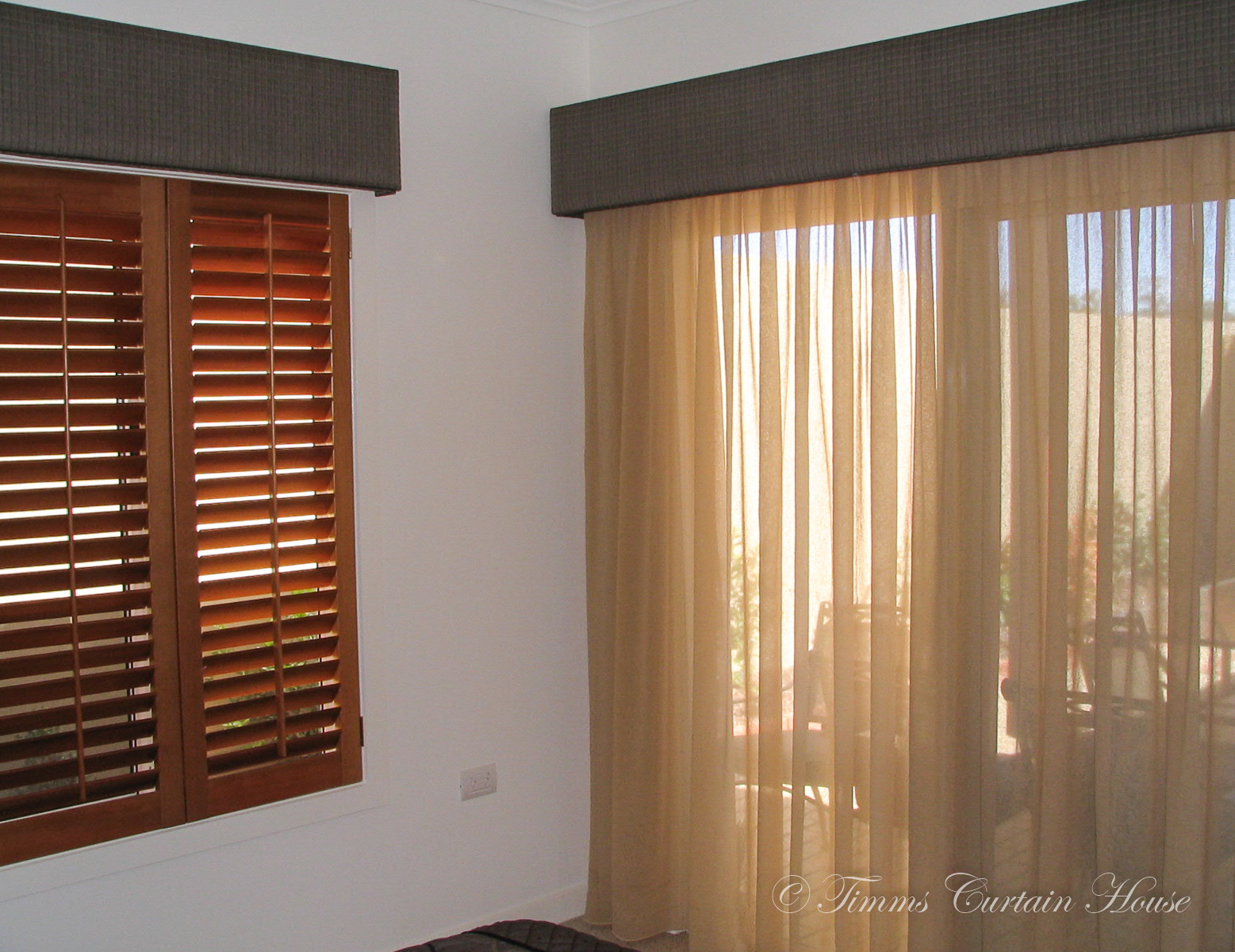 Pelmet over wooden shutters and sheers