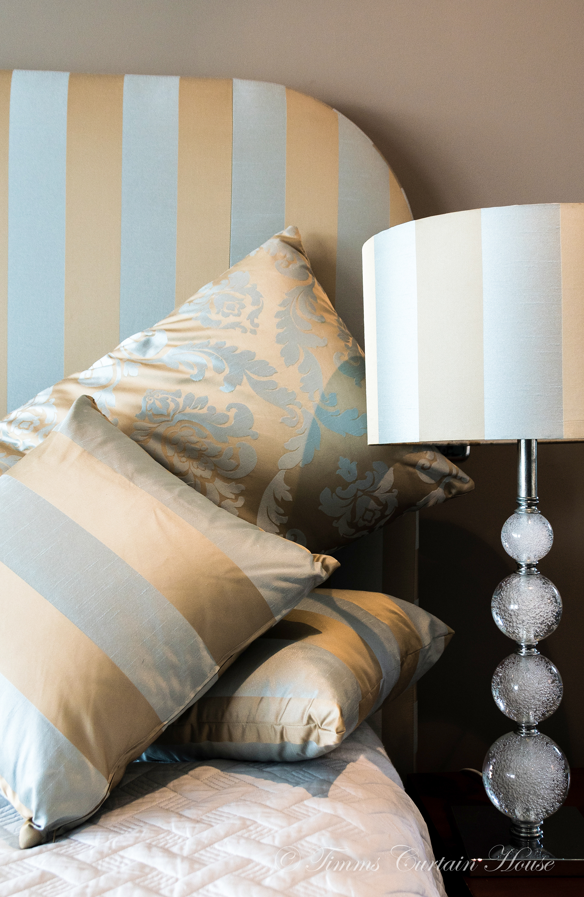 Shaped bedhead with cushions and lampshade