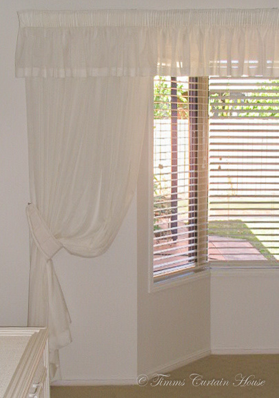 Valance and tie back over venetians in bay window