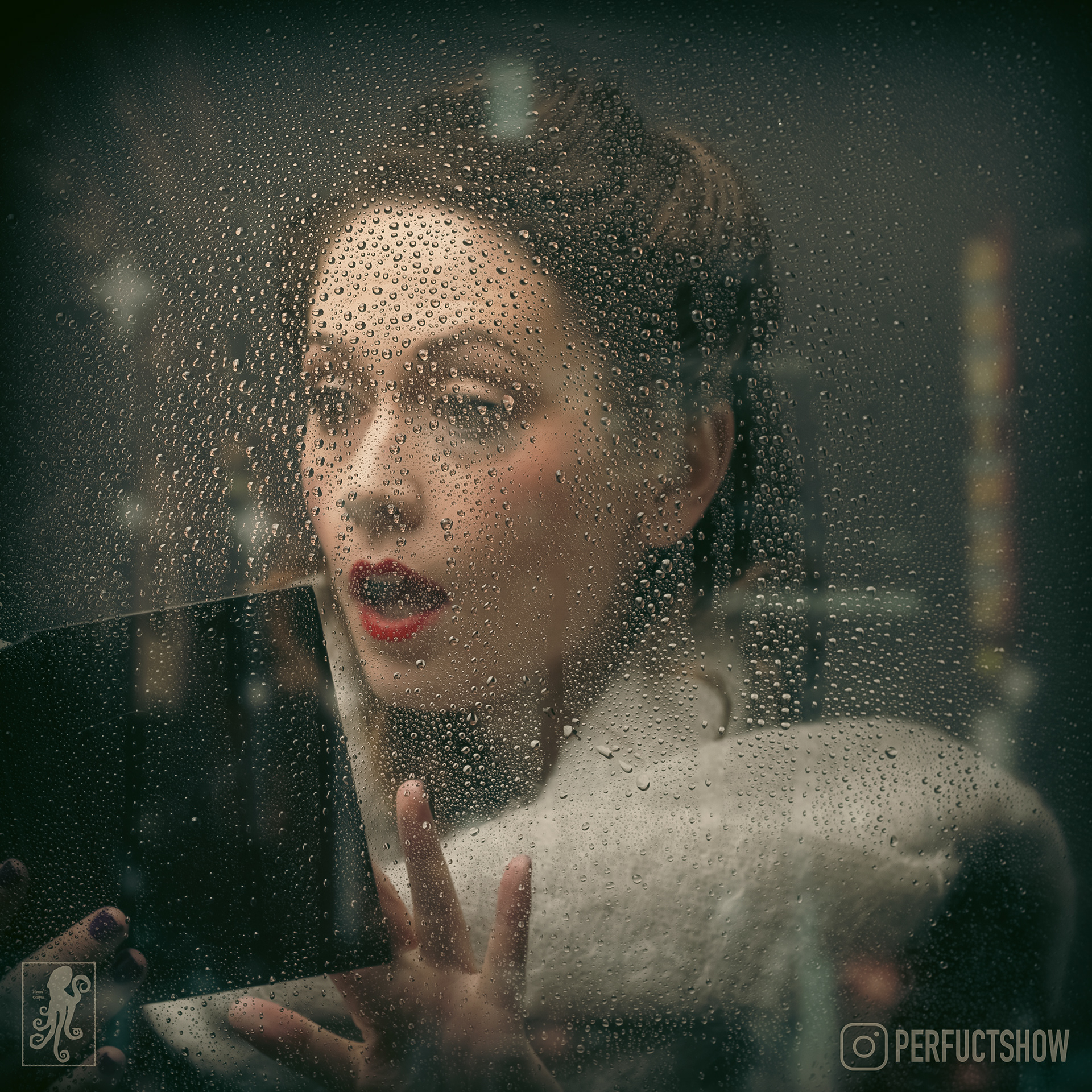 Comedian Kathleen Burns wears a wooly scarf and can be seen through a rainy window checking her diary to see if she is available for corporate performances on a specific date.