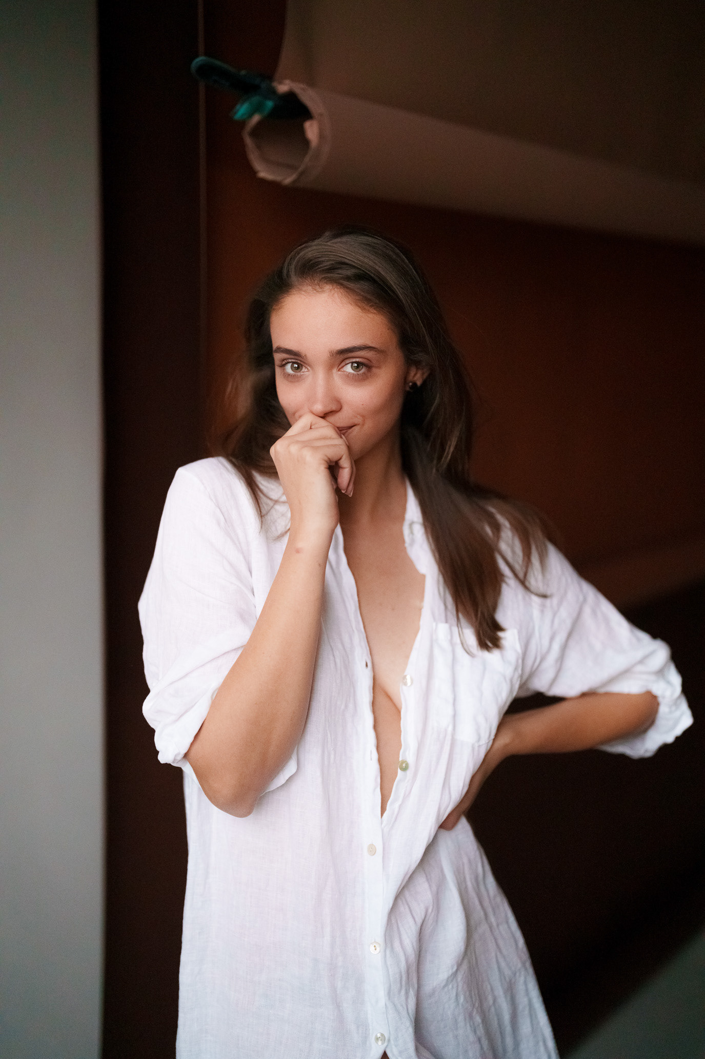 Portrait of actor Teona Stavarachi in a white shirt with one hand near her mouth, photographed by Alex Gâlmeanu.