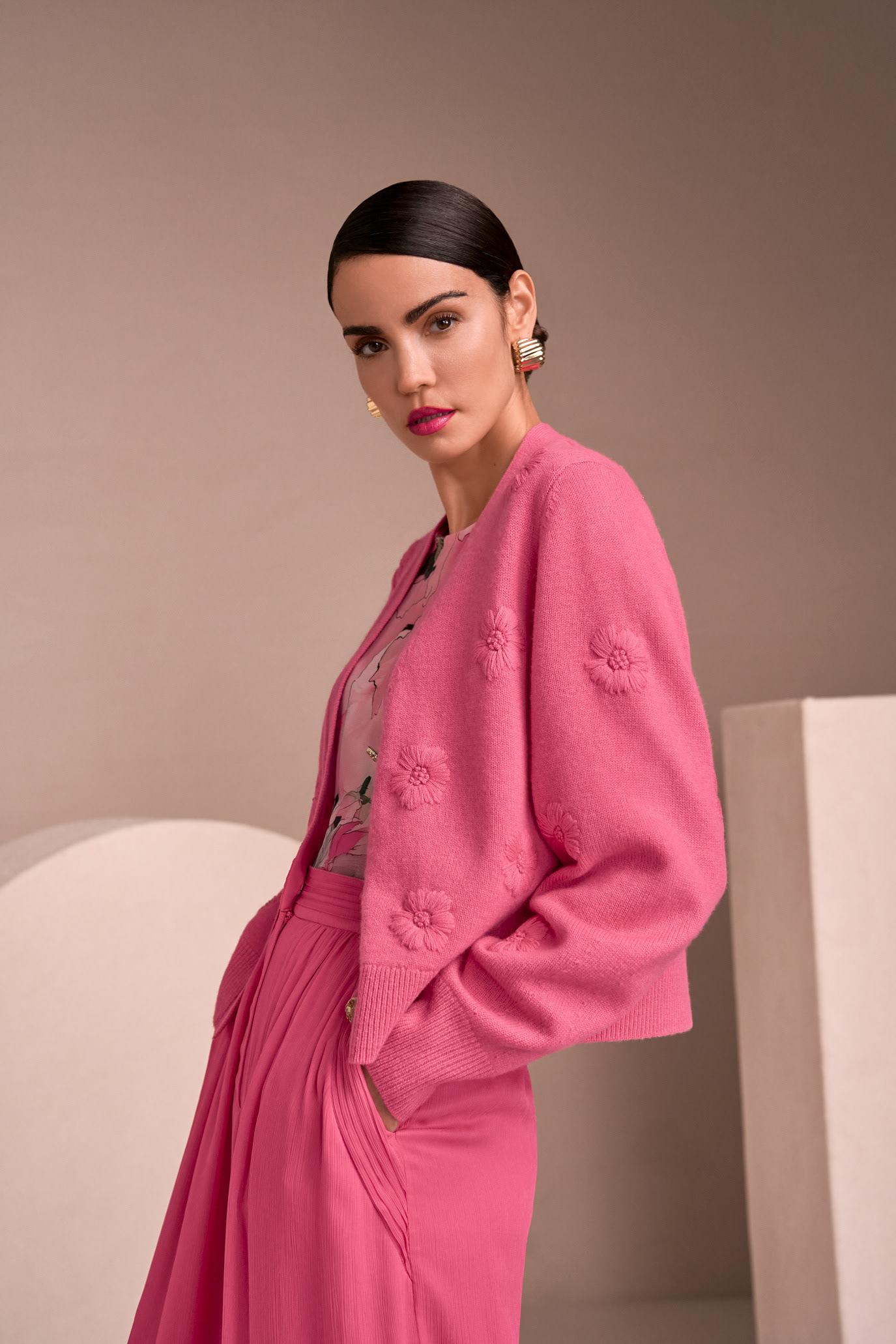Sofia Resing in a pink Marc Cain suit against a neutral geometric set, photographed by Alex Galmeanu.
