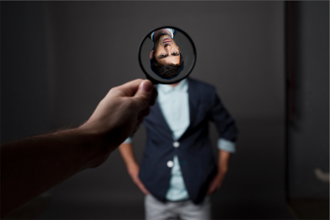 Paul Ipate blurred behind a hand mirror that reflects his face upside down, photographed by Alex Gâlmeanu.