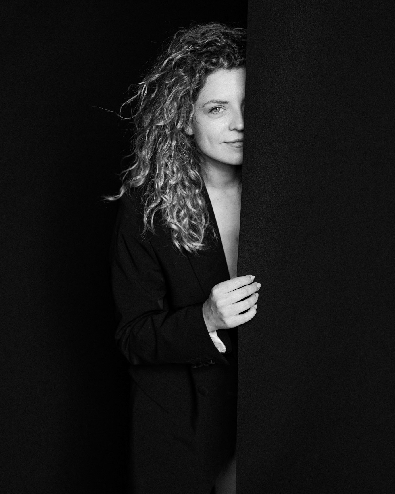Black-and-white portrait of actor Victoria Raileanu emerging from a dark background, photographed by Alex Gâlmeanu.