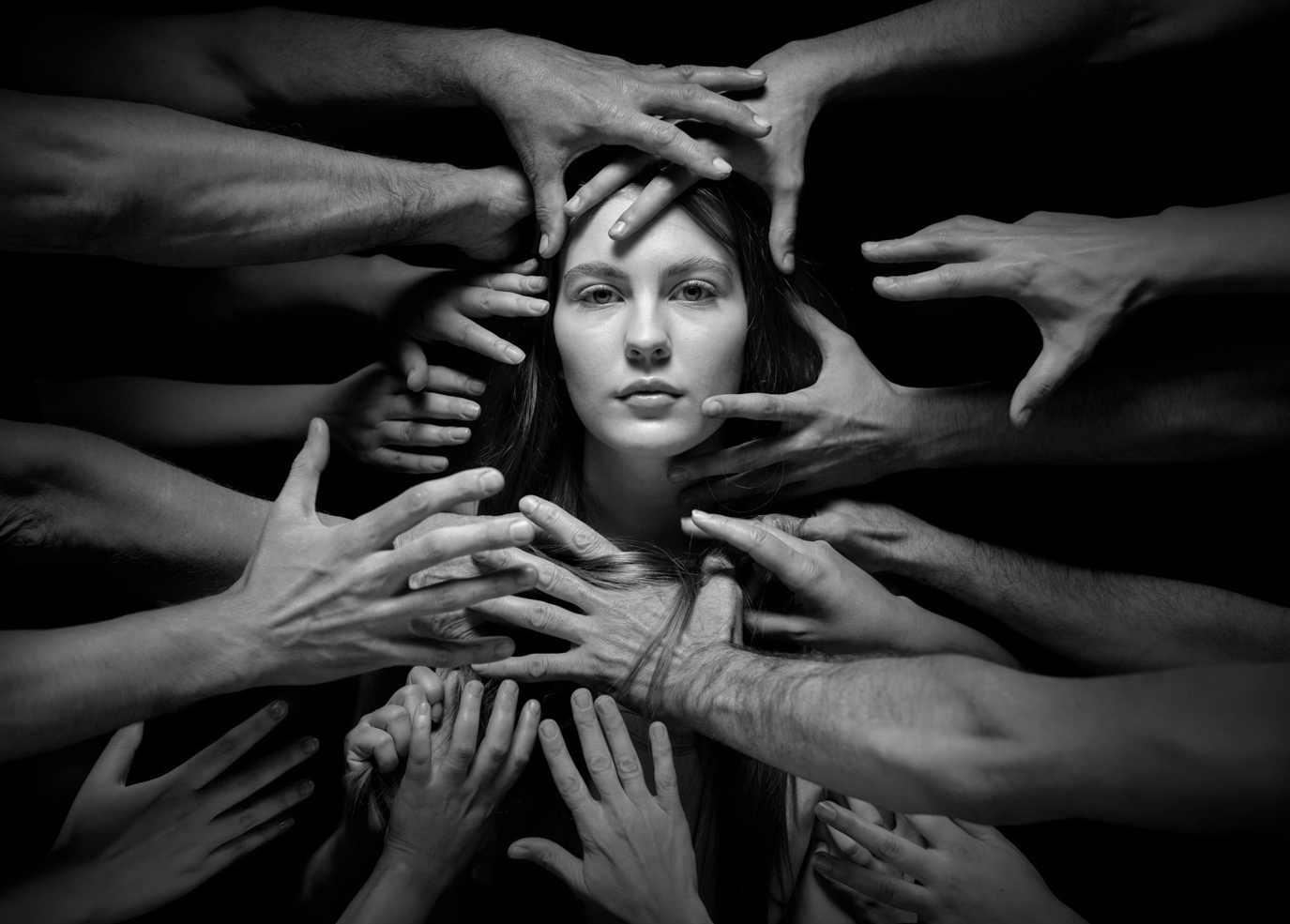 Young woman’s face framed by many reaching hands for the Child Helpline Association and Romanian Police, photographed by Alex Gâlmeanu.
