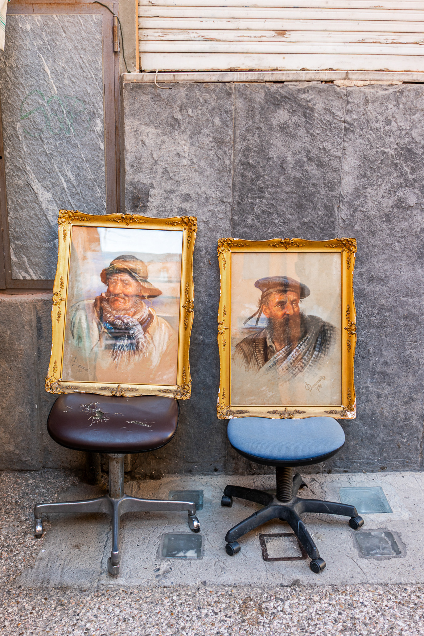 Two painted portraits displayed on office chairs in Lucca, Italy. Photograph by Alex Galmeanu.