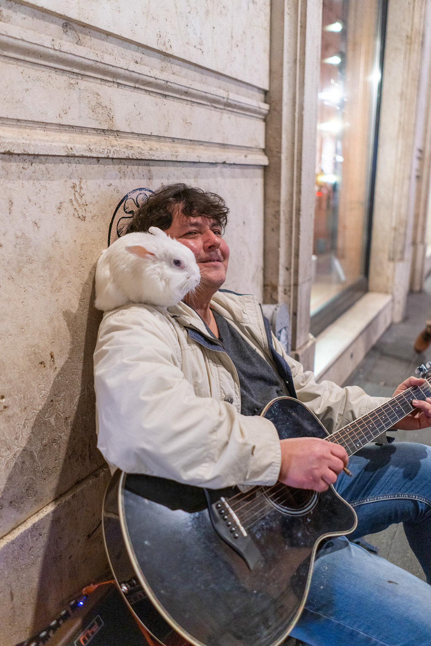 A street musician with a white cat on his shoulder in Rome, Italy. Photograph by Alex Galmeanu.