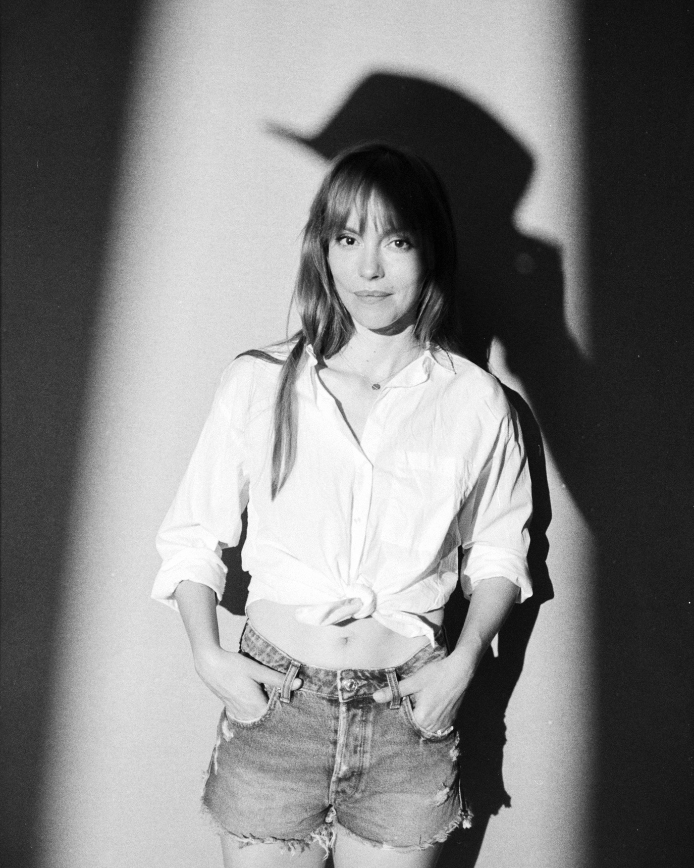 Olimpia Melinte in a white shirt and shorts casting a dramatic shadow, photographed by Alex Gâlmeanu.