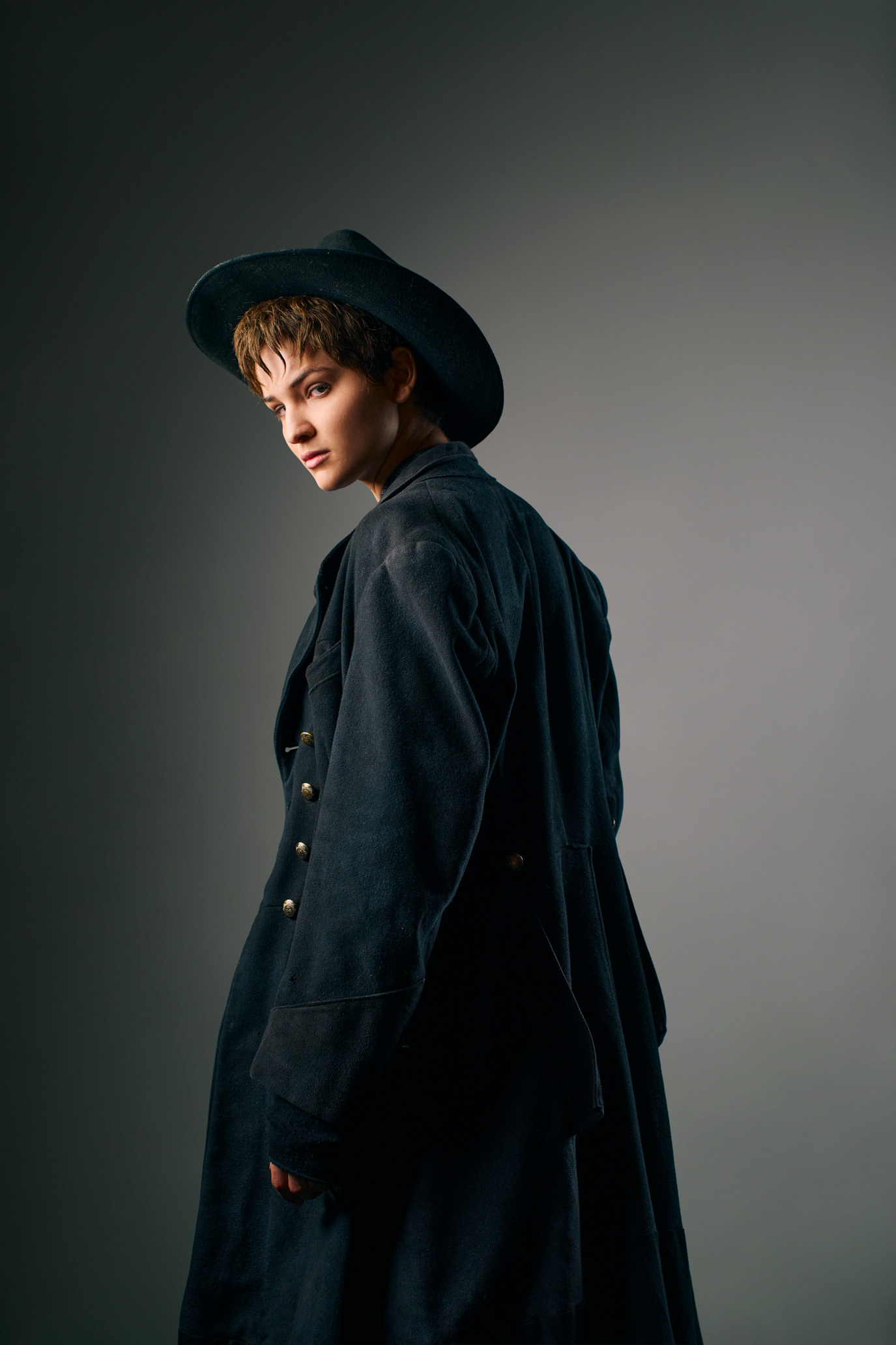 Lisa Vicari in profile wearing a dark western costume and hat, photographed by Alex Gâlmeanu.