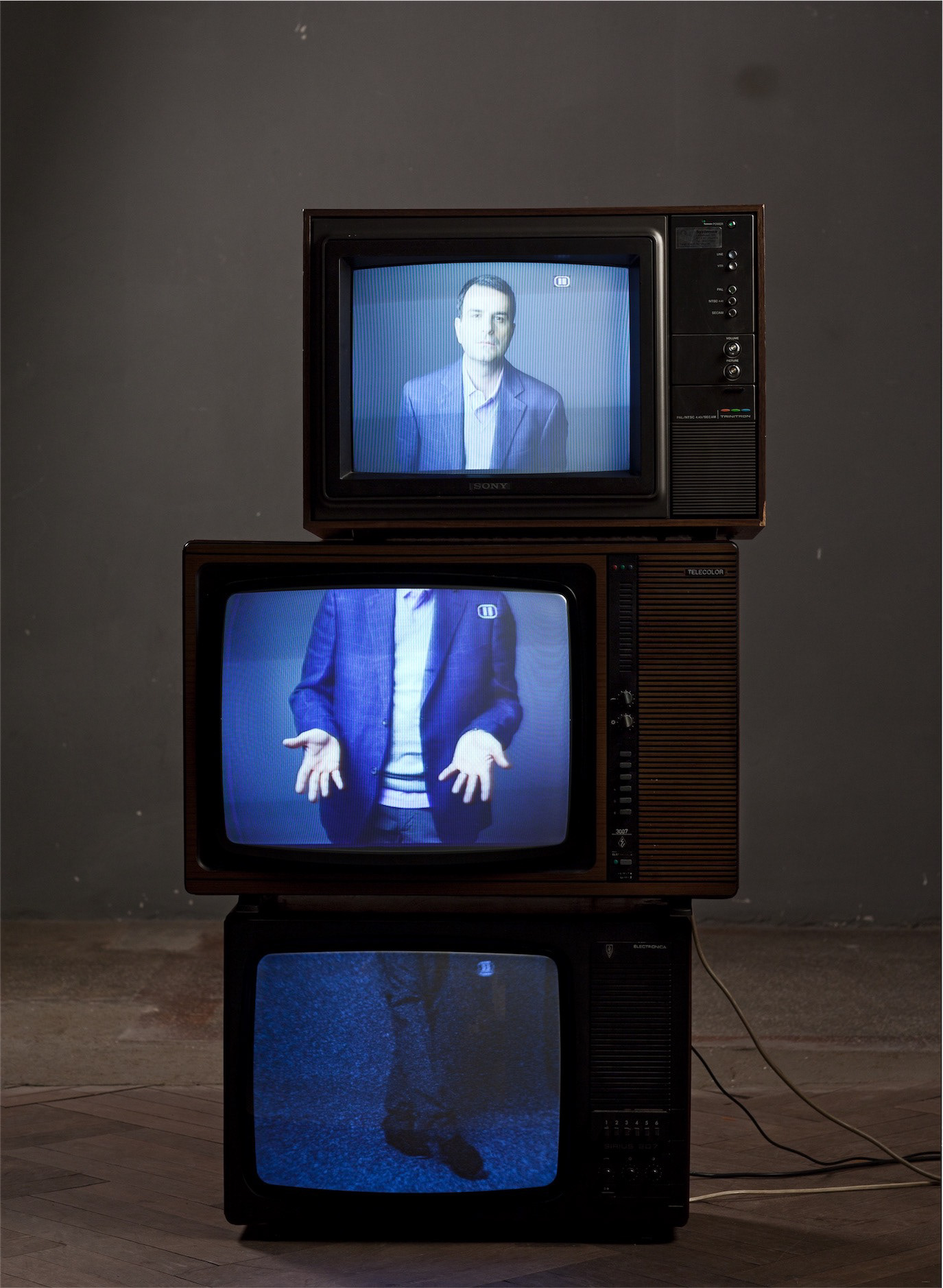 Lucian Mîndruță appearing across three stacked vintage television screens, photographed by Alex Gâlmeanu.