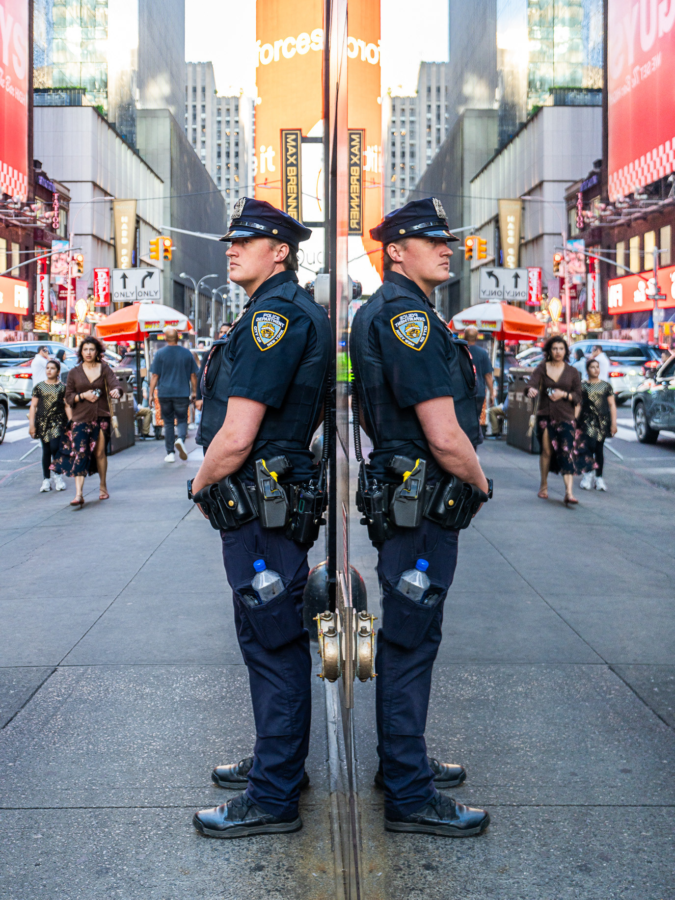 A police officer doubled by a mirrored Times Square installation in New York, USA. Photograph by Alex Galmeanu.
