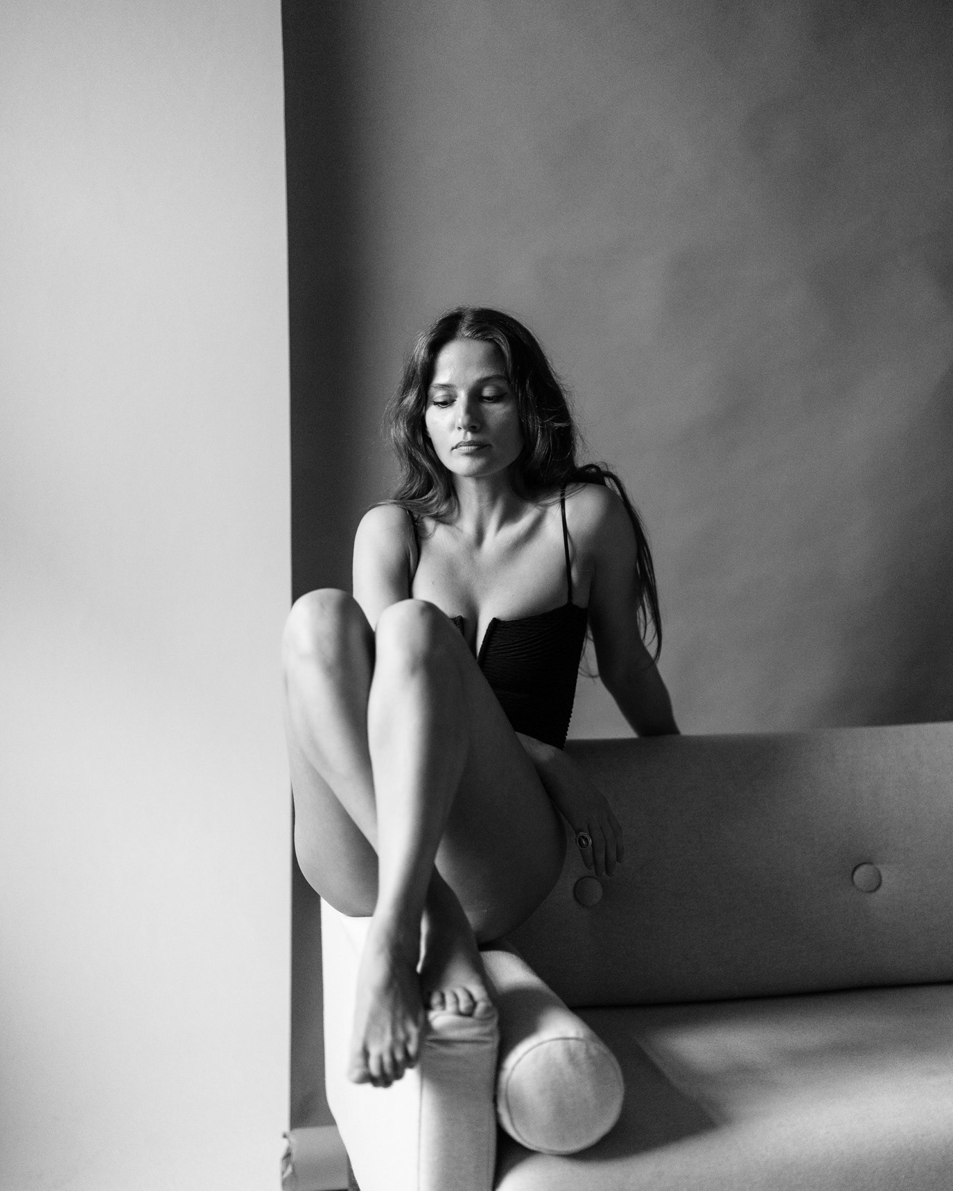 Black-and-white portrait of actor Aida Economu seated on a sofa, photographed by Alex Gâlmeanu.