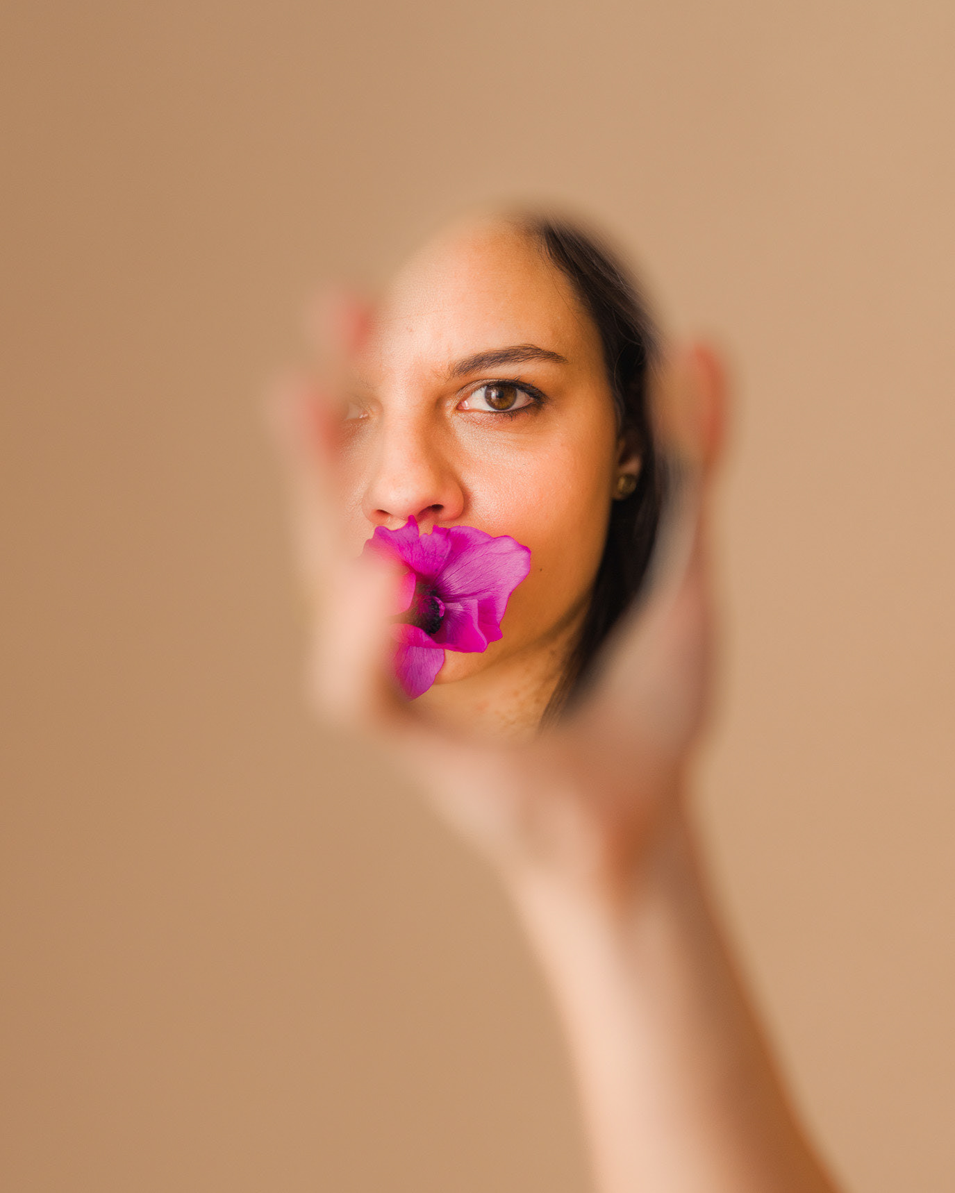 Portrait of actor Madalina Craiu with a flower at her mouth and one hand framing her face, photographed by Alex Gâlmeanu.