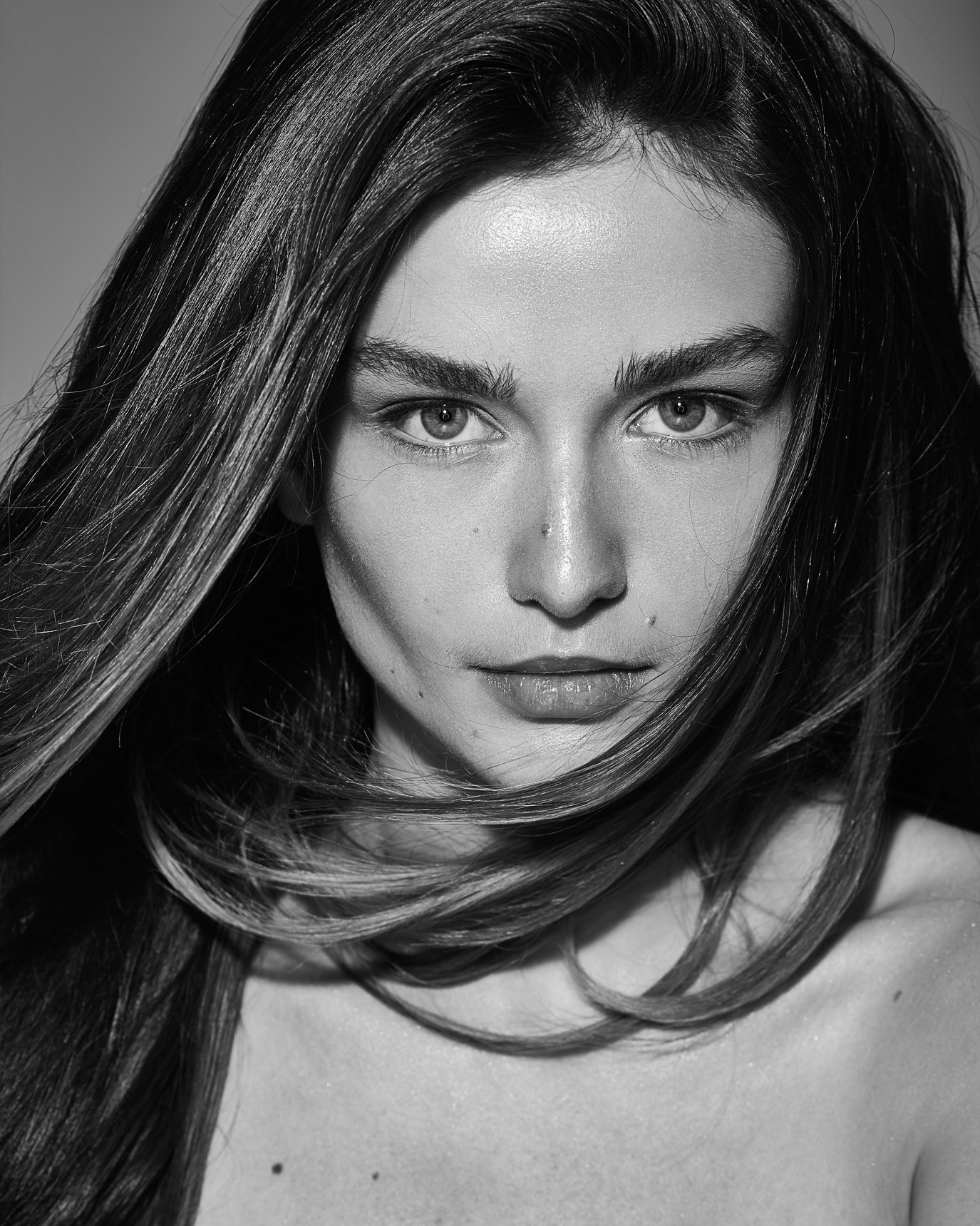 Black-and-white close-up portrait of Andreea Diaconu for Harper’s Bazaar Romania, photographed by Alex Galmeanu.