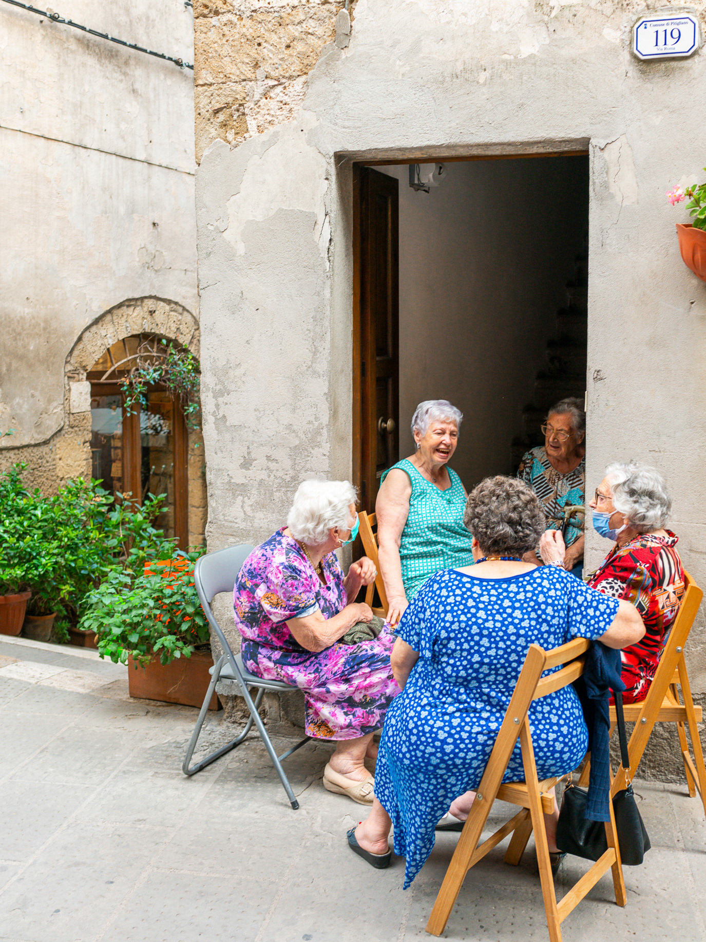 A group of elderly women talking outside a doorway in Pitigliano, Italy. Photograph by Alex Galmeanu.