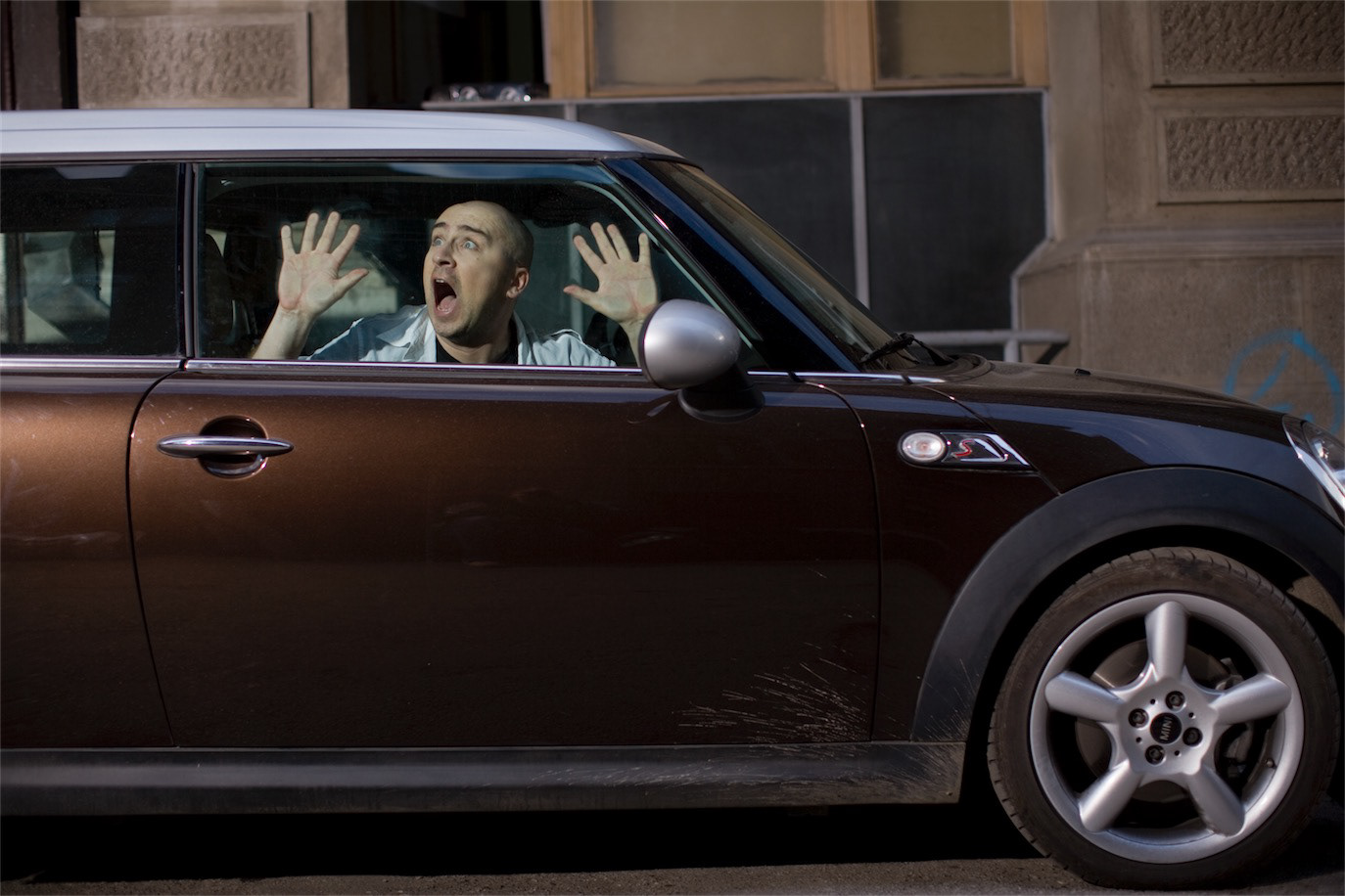 Mihai Dobrovolschi pressing his hands and face against a car window, photographed by Alex Gâlmeanu.