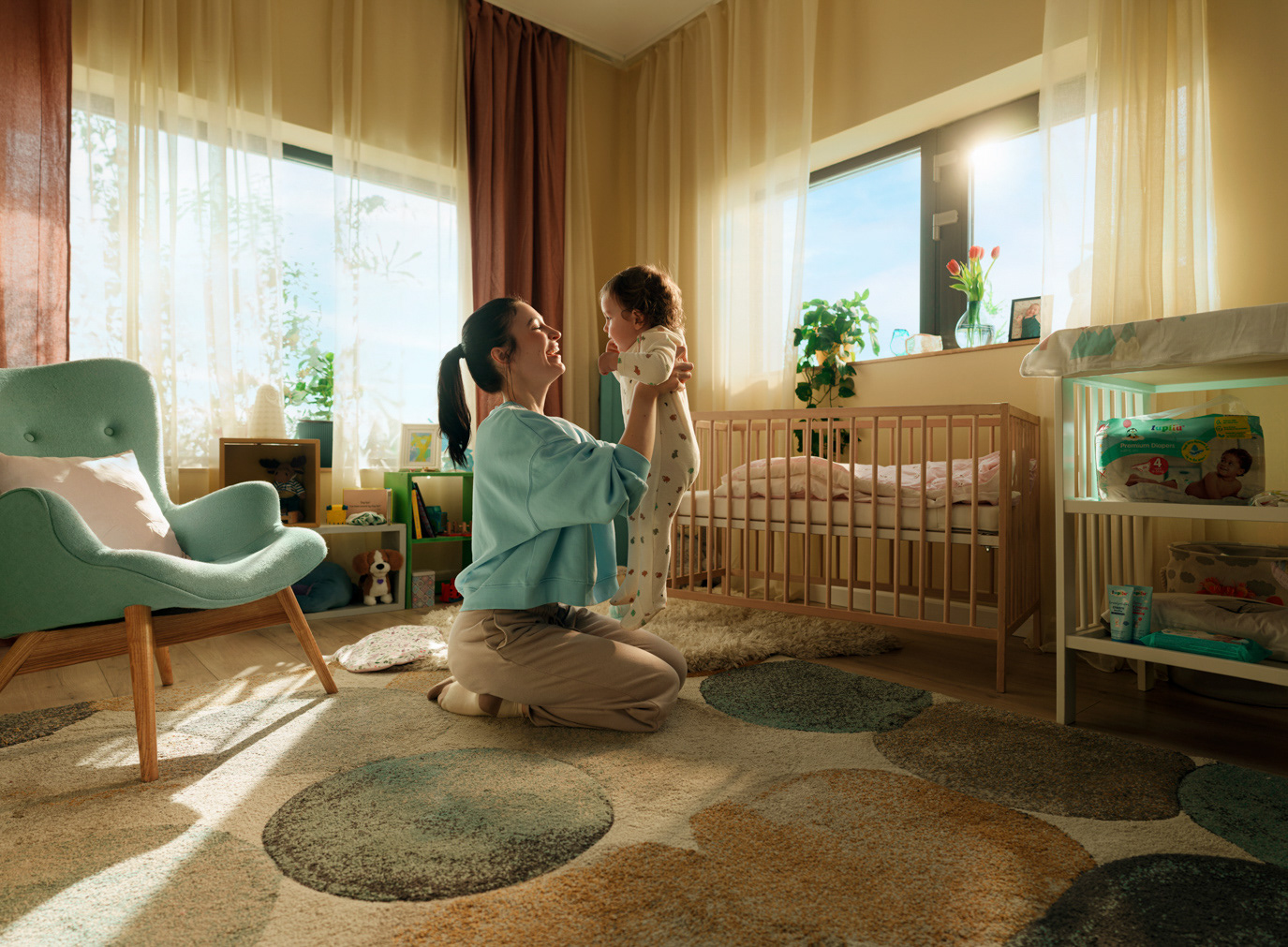 Mother lifting her baby in a sunlit nursery for Lidl Lupilu, photographed by Alex Gâlmeanu.