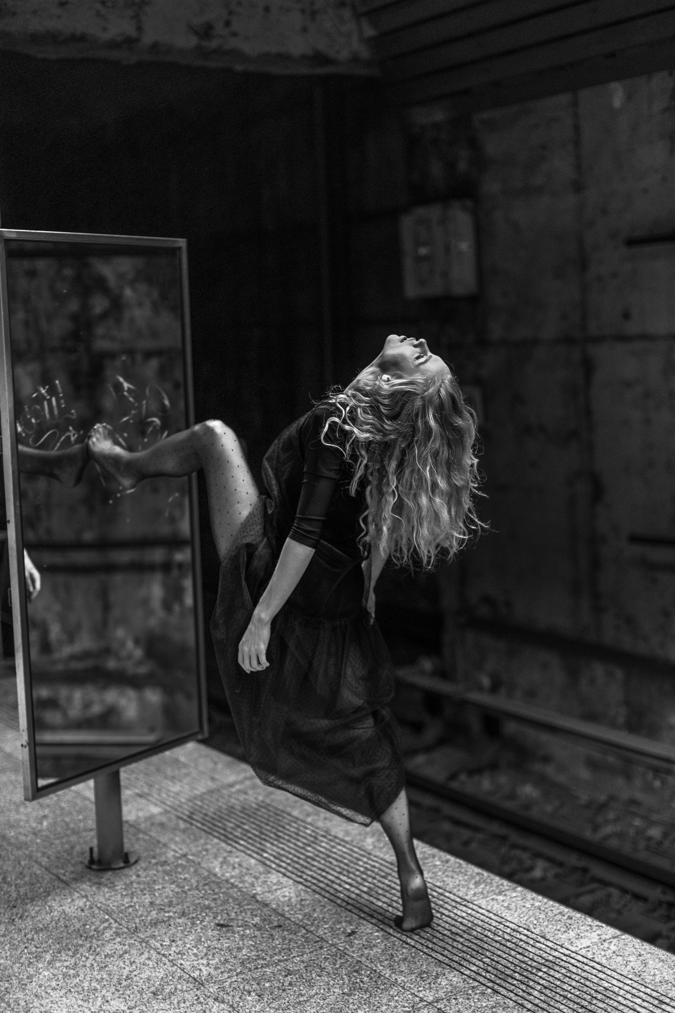 Black-and-white portrait of gymnast Anca Surdu posing beside a mirror in the studio, photographed by Alex Gâlmeanu.