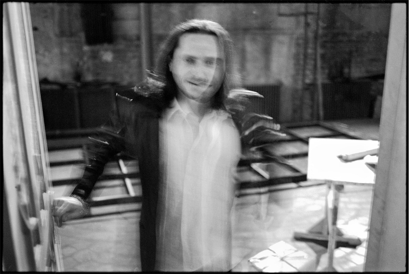 Motion-blurred black-and-white portrait of Claudiu Bleonț seen through glass, photographed by Alex Gâlmeanu.