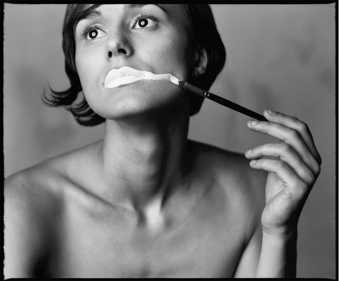 Silvana Bratu having white makeup painted across her lips in a black-and-white close-up, photographed by Alex Gâlmeanu.