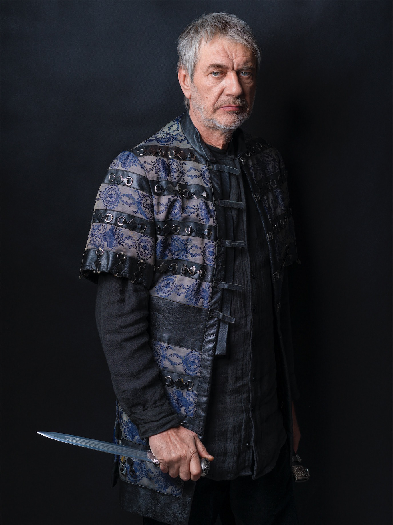 Marcel Iureș in period costume holding a sword against a dark background, photographed by Alex Gâlmeanu.