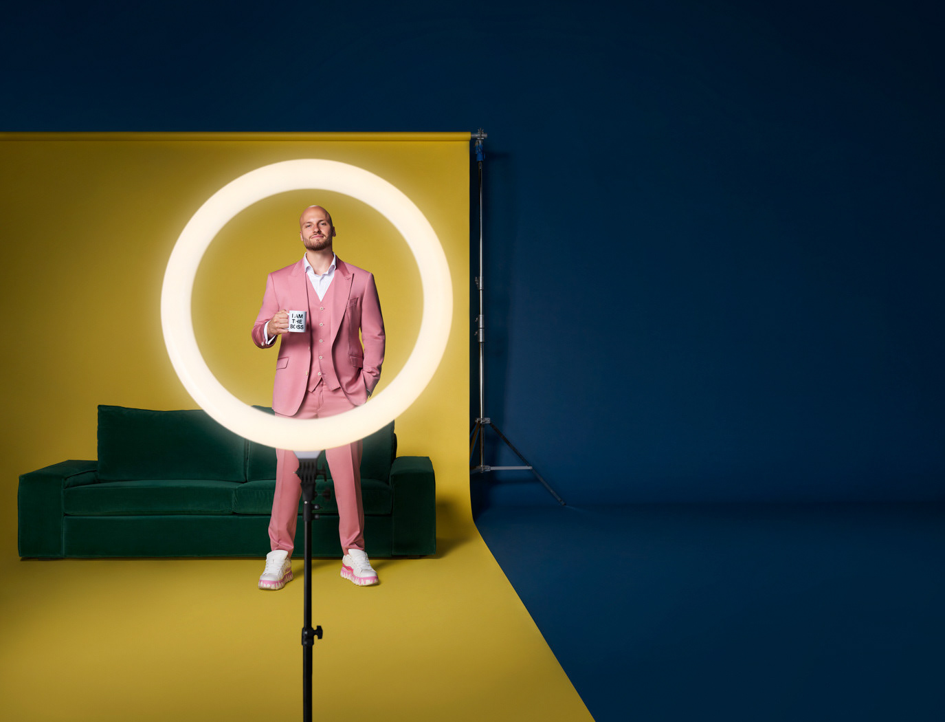 Man framed by a circular yellow light on a blue-and-green set for Salt Bank, photographed by Alex Gâlmeanu.