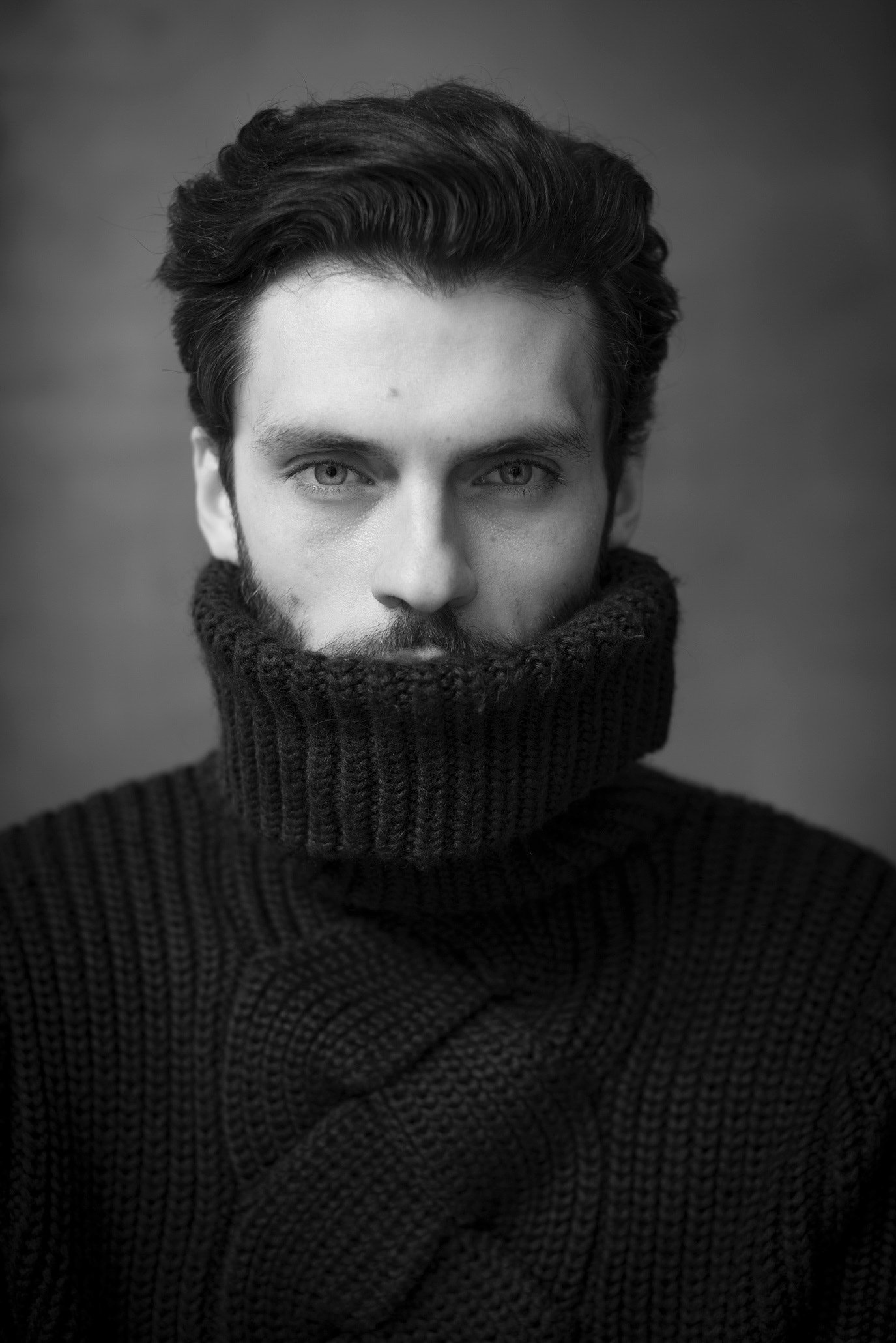 Black-and-white close portrait of model Silviu Tolu with a high collar covering his mouth, photographed by Alex Gâlmeanu.