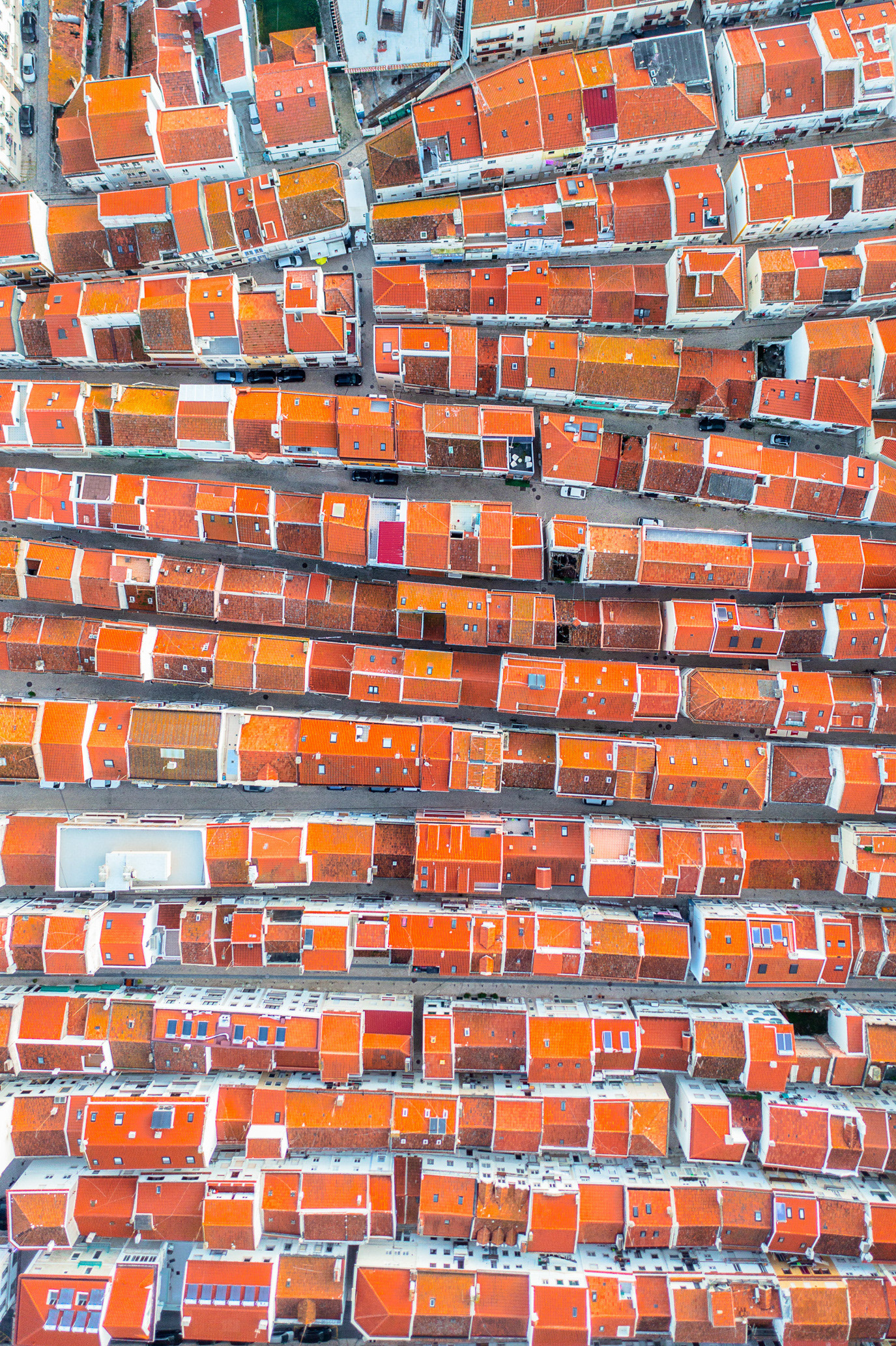 Rows of orange rooftops forming a graphic aerial pattern in Nazaré, Portugal. Photograph by Alex Galmeanu.