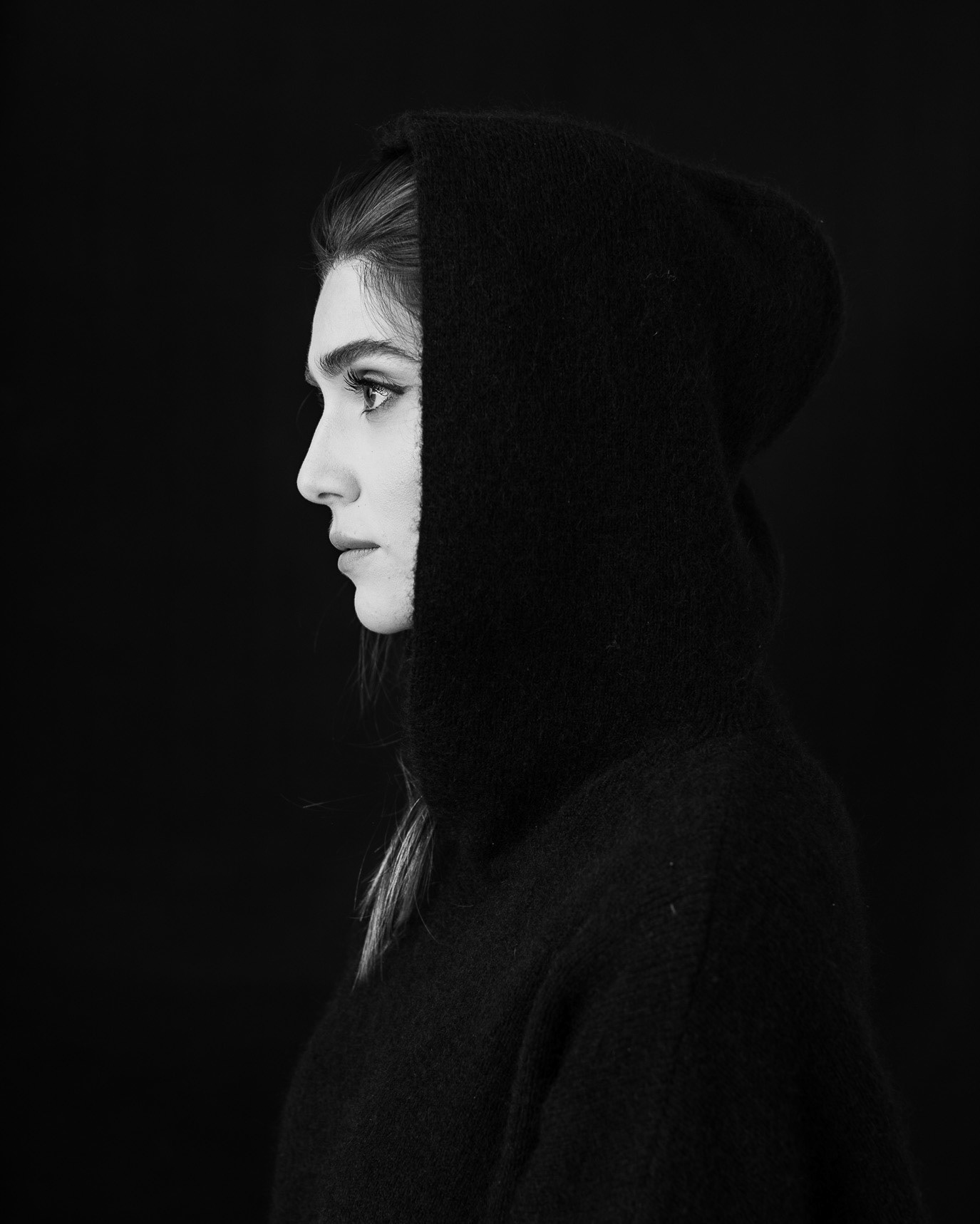 Black-and-white profile portrait of model Cristiana Mitrea in a dark hooded garment, photographed by Alex Gâlmeanu.