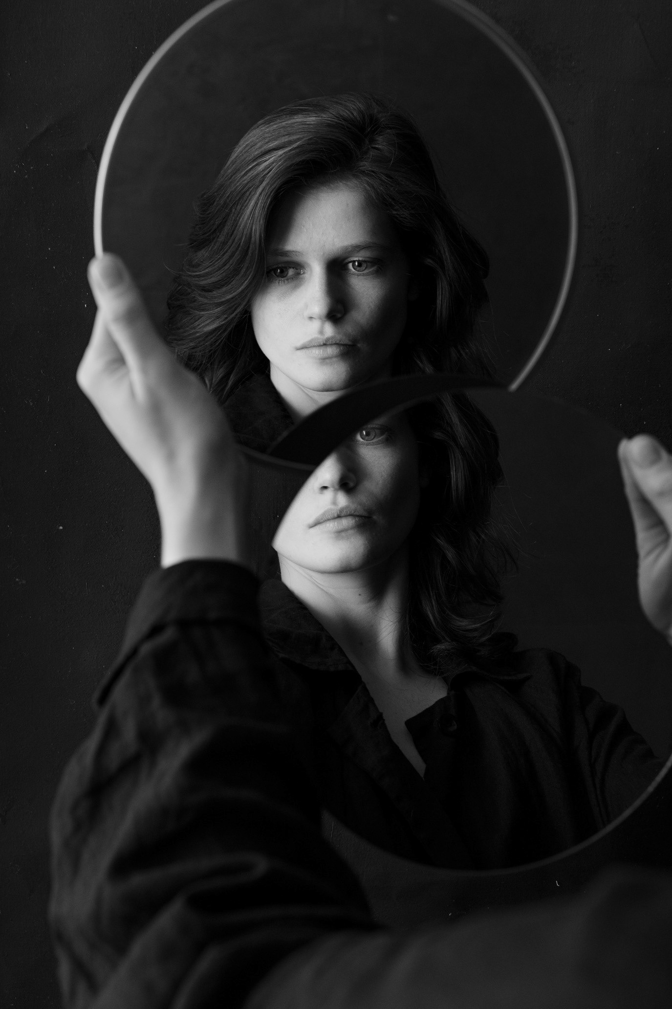 Black-and-white portrait of model Marta Marghidanu reflected through two circular mirrors, photographed by Alex Gâlmeanu.