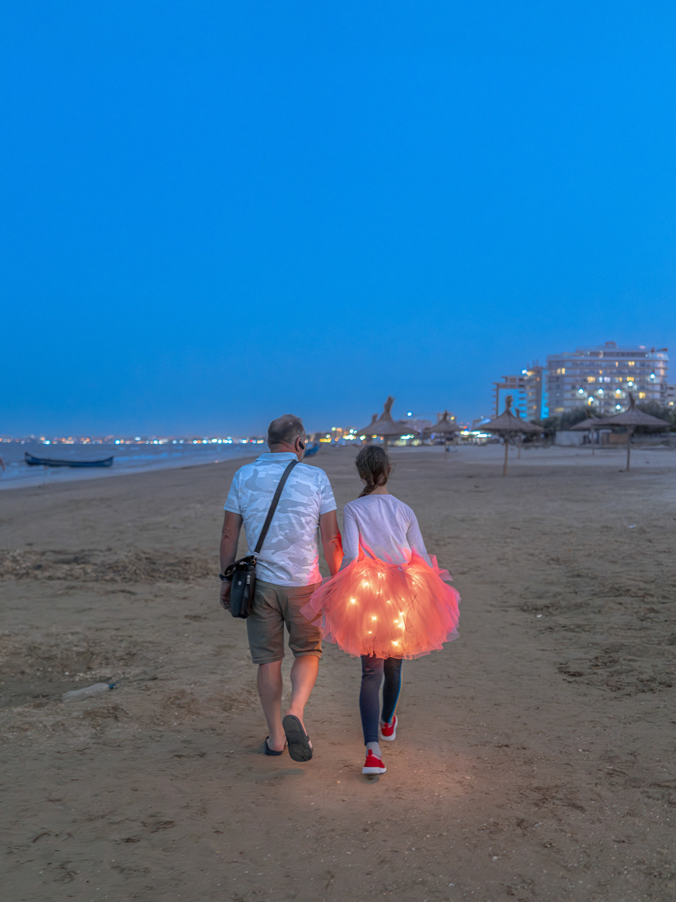 Father and doughter walking along the beach, in Constanța, Romania. Photograph by Alex Galmeanu.