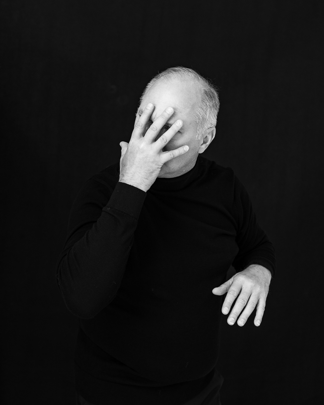 Black-and-white portrait of Vlad Ivanov covering his face with one hand, photographed by Alex Gâlmeanu.
