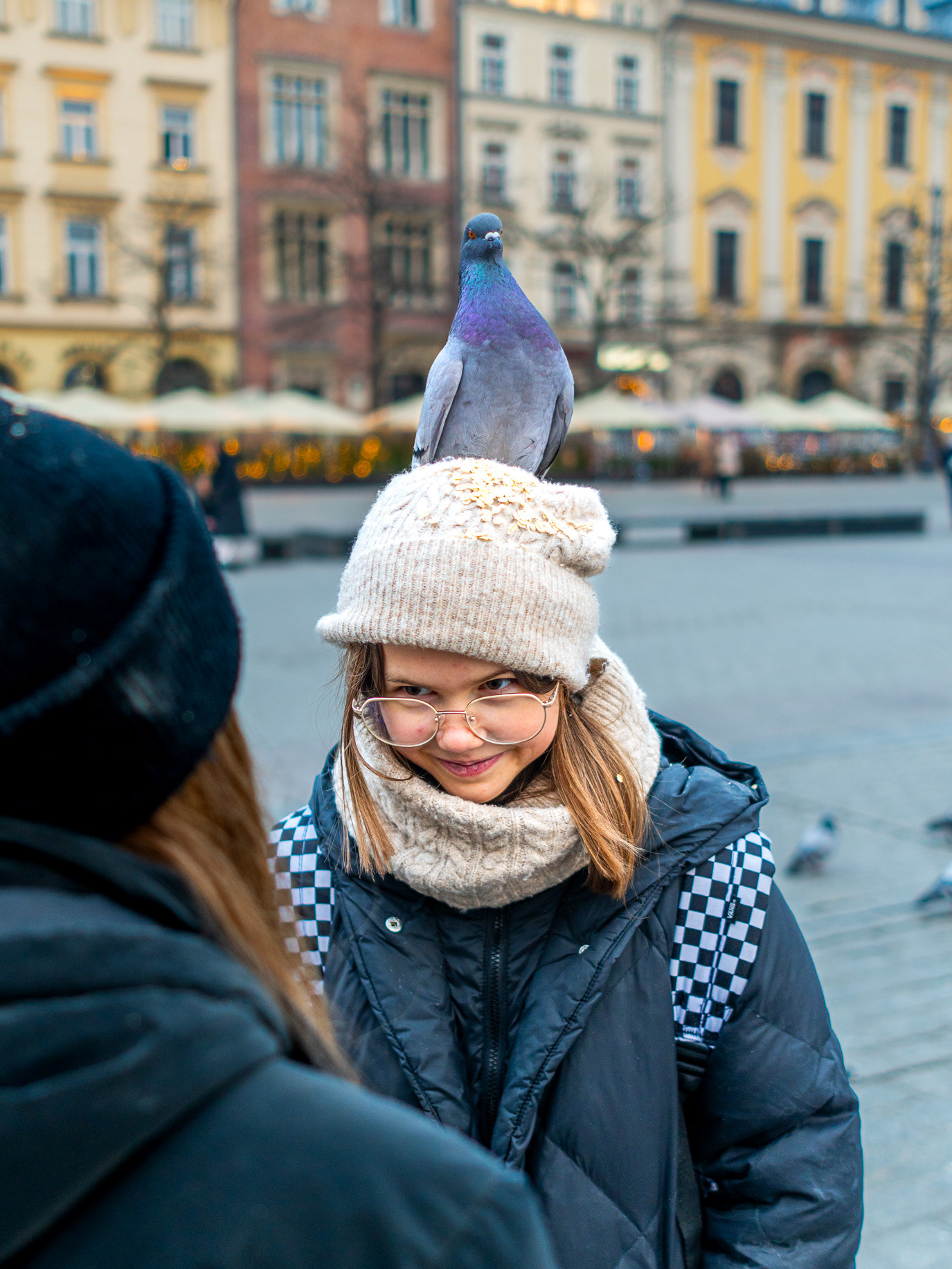 A pigeon perched on a woman’s wool hat in Kraków, Poland. Photograph by Alex Galmeanu.