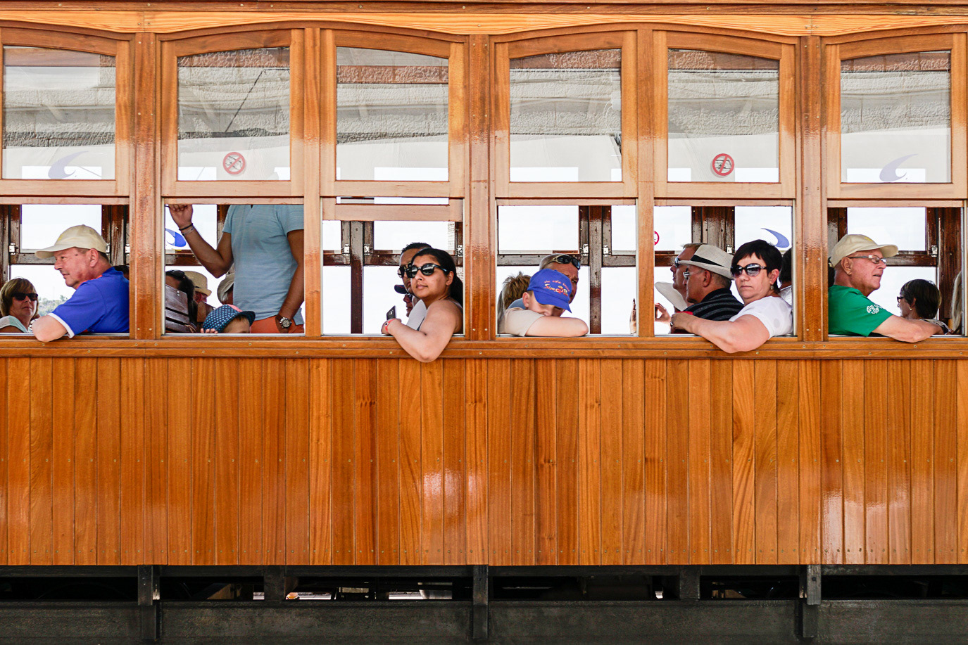 Passengers framed in the wooden windows of a historic tram in Mallorca, Spain. Photograph by Alex Galmeanu.