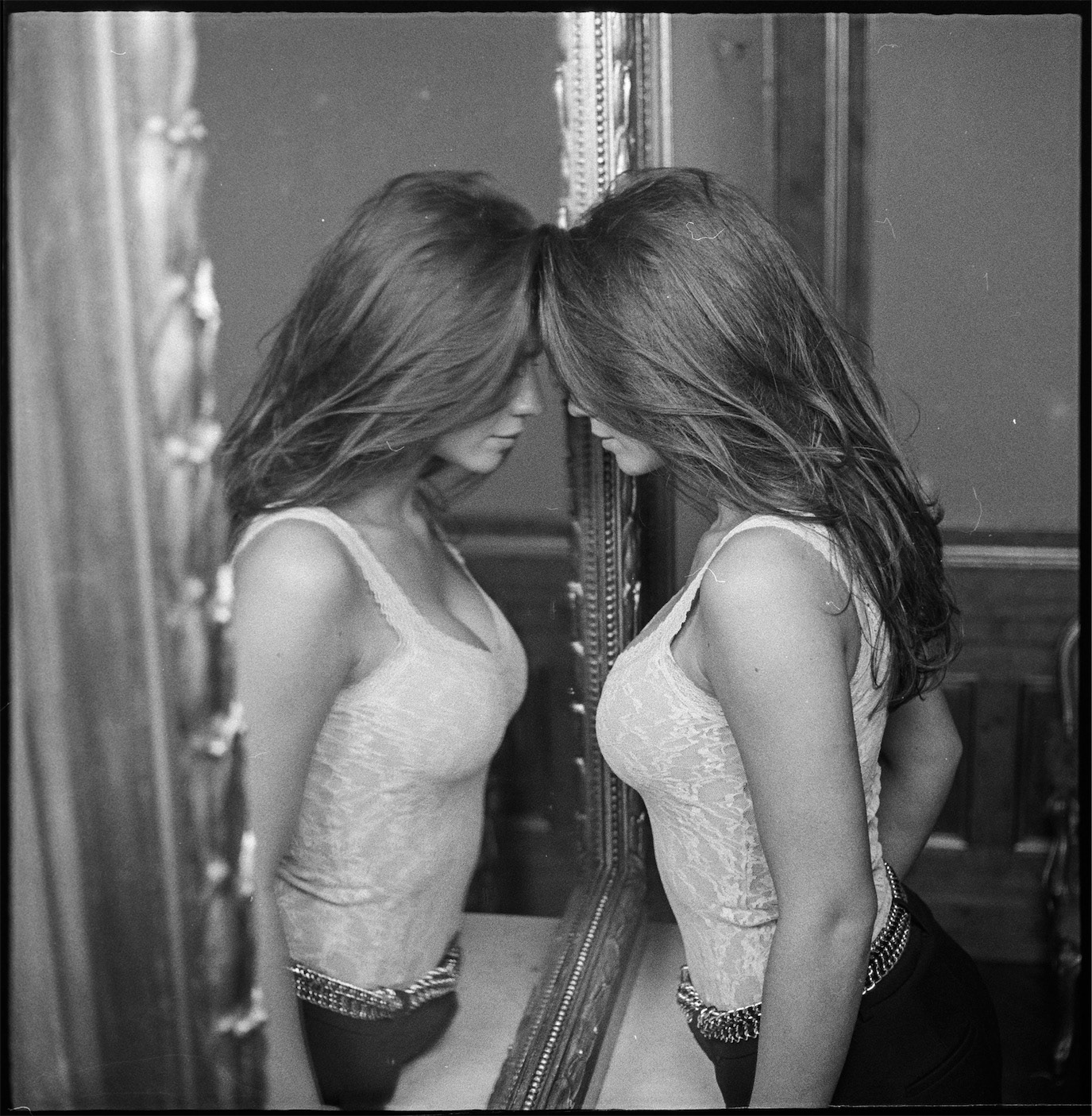 Ada Condeescu touching her forehead to her mirror reflection in black and white, photographed by Alex Gâlmeanu.