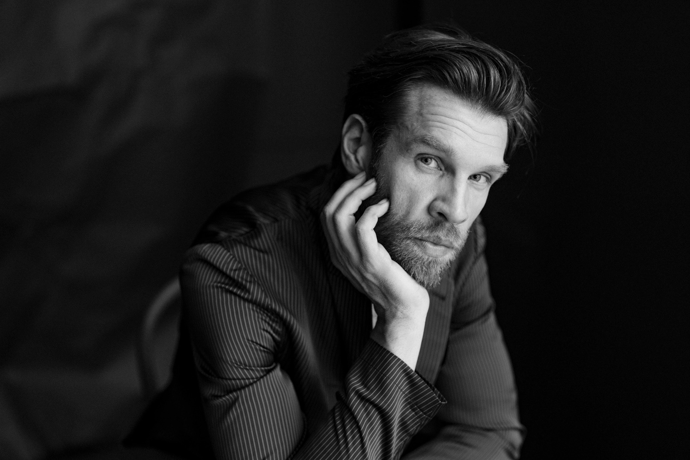 Marc Rissmann resting his face on one hand in a black-and-white portrait, photographed by Alex Gâlmeanu.