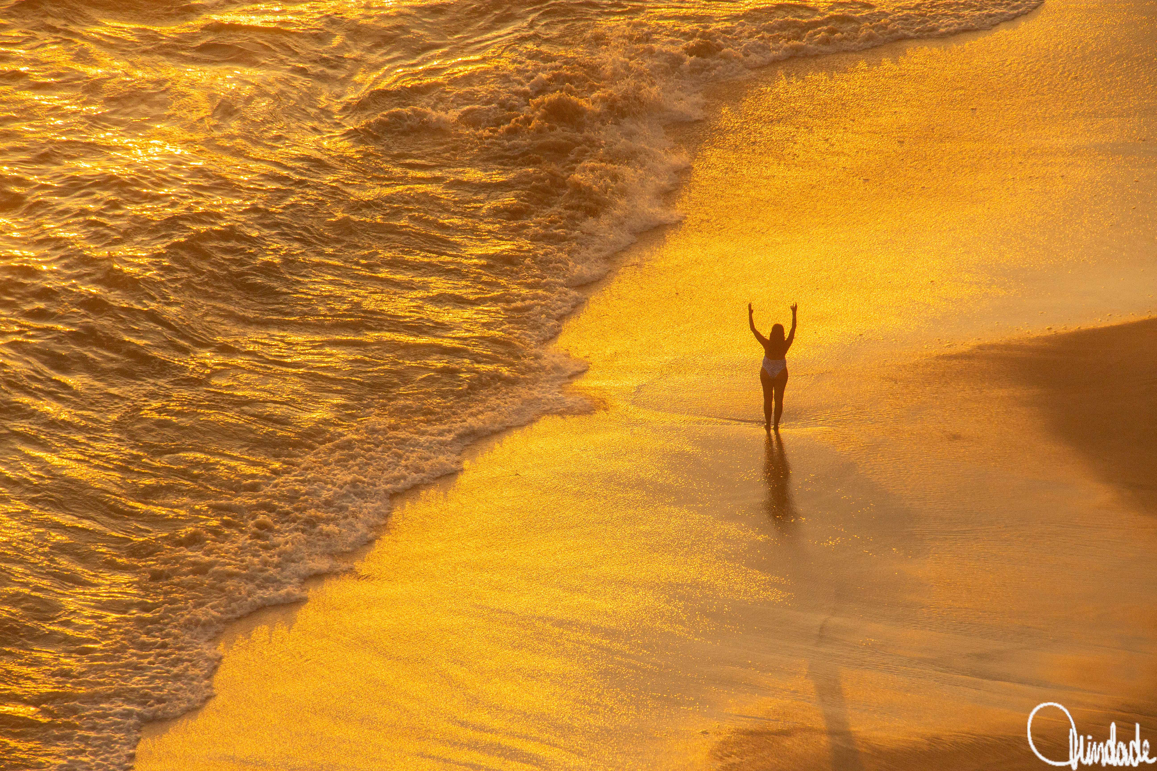 Cena ao pôr do sol na praia da Boa Viagem, Niterói (RJ), com reflexos dourados na areia molhada