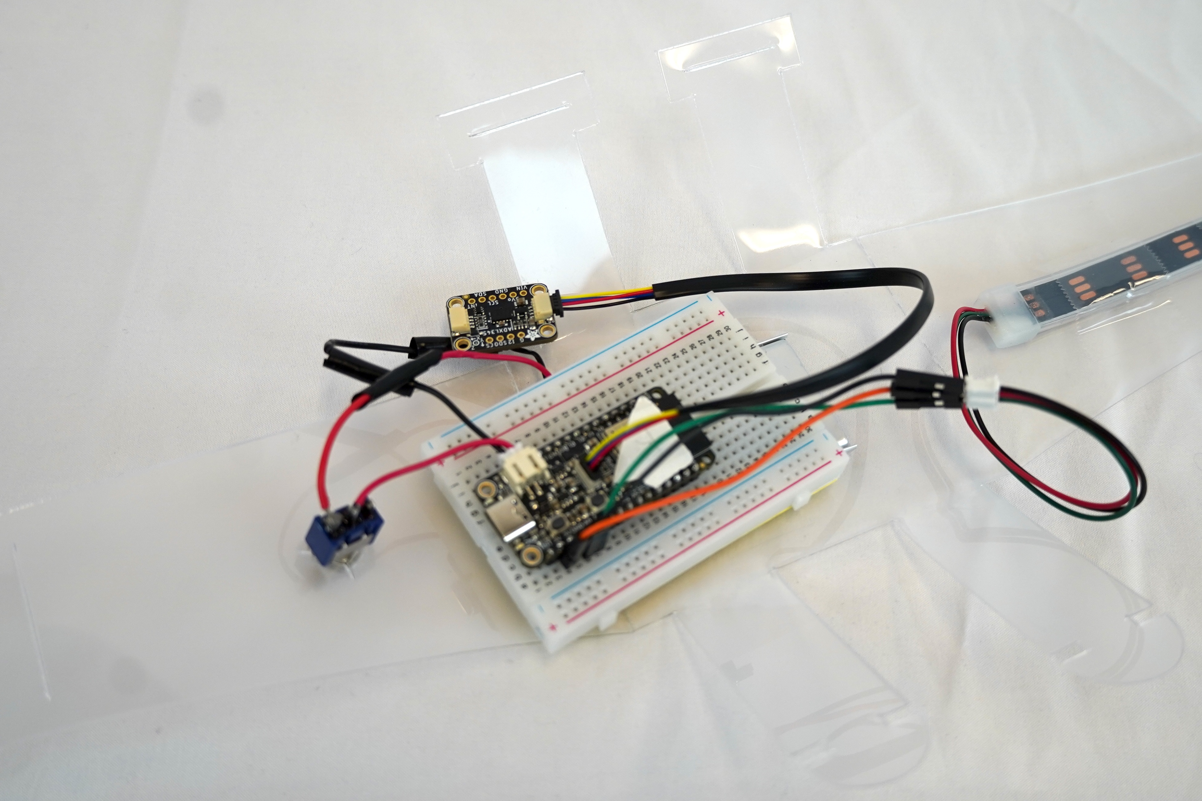 Close up view of the internal components. (Left to right: Toggle Switch, Accelerometer, Microcontroller, 400 Pin Breadboard, LED strip).