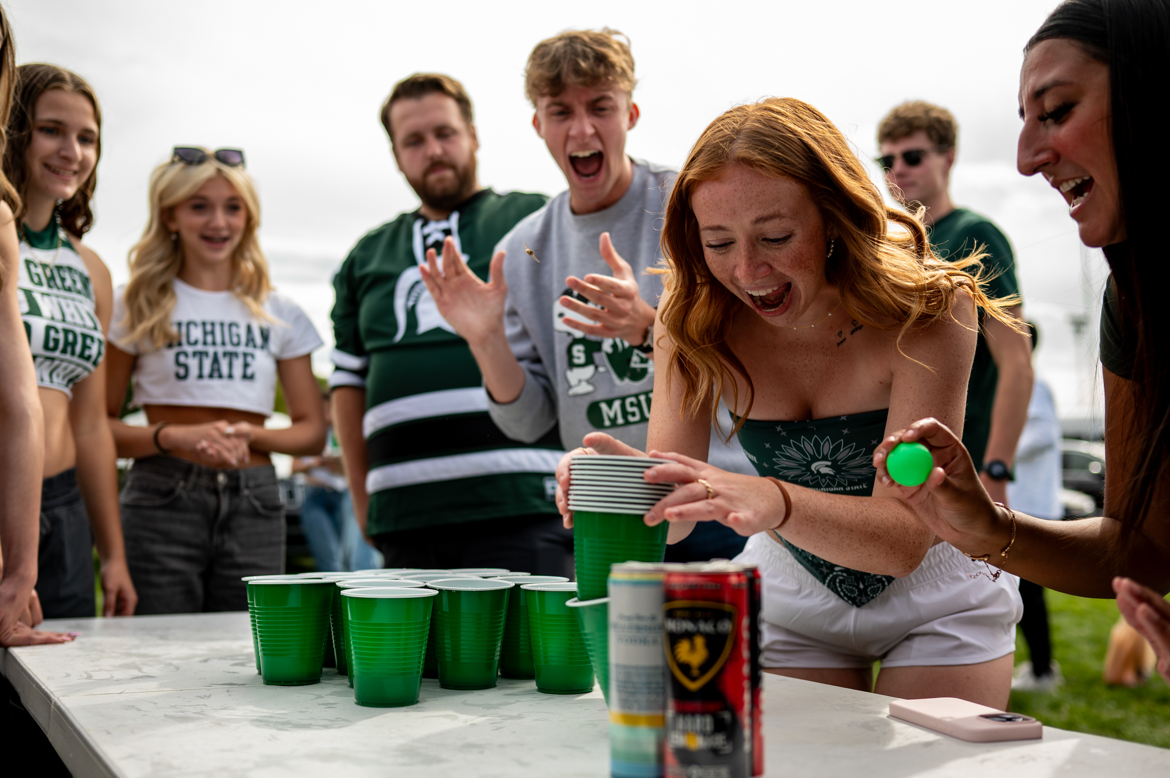 Chloe Ihamonan, 20, of Grand Rapids, plays a table-top game along with other Michigan State Fans while at the Russ family tailgate Michigan State University's Munn Intramural Field ahead of the first game of the 2025 season against Western Michigan University in East Lansing, Michigan on Aug. 29, 2025. 