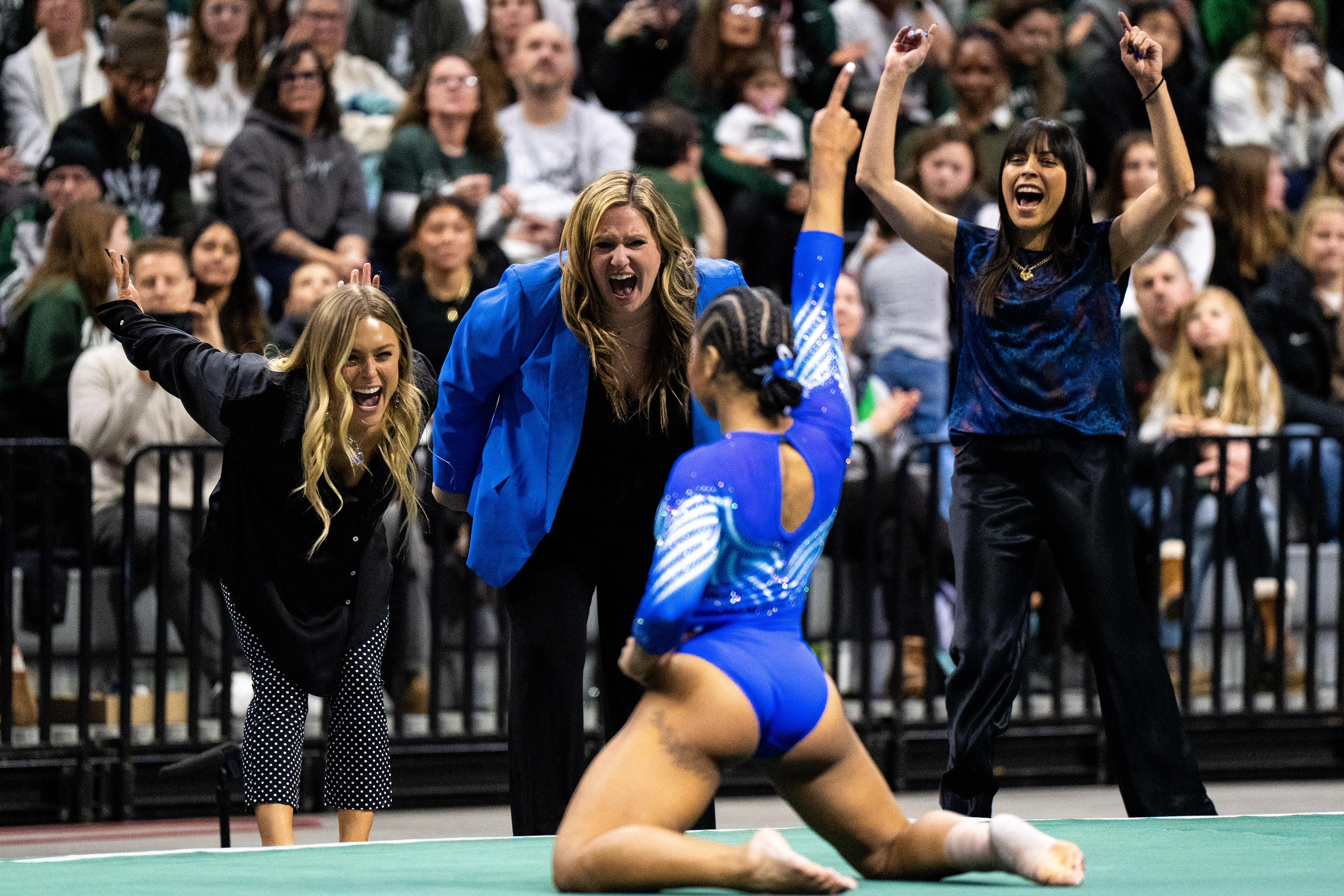 UCLA coaches celebrate with Olympian and UCLA athlete Jordan Chiles after her floor routine during a meet against Michigan State at the Breslin Center in East Lansing, Mich., on Sunday, Jan. 25, 2026.