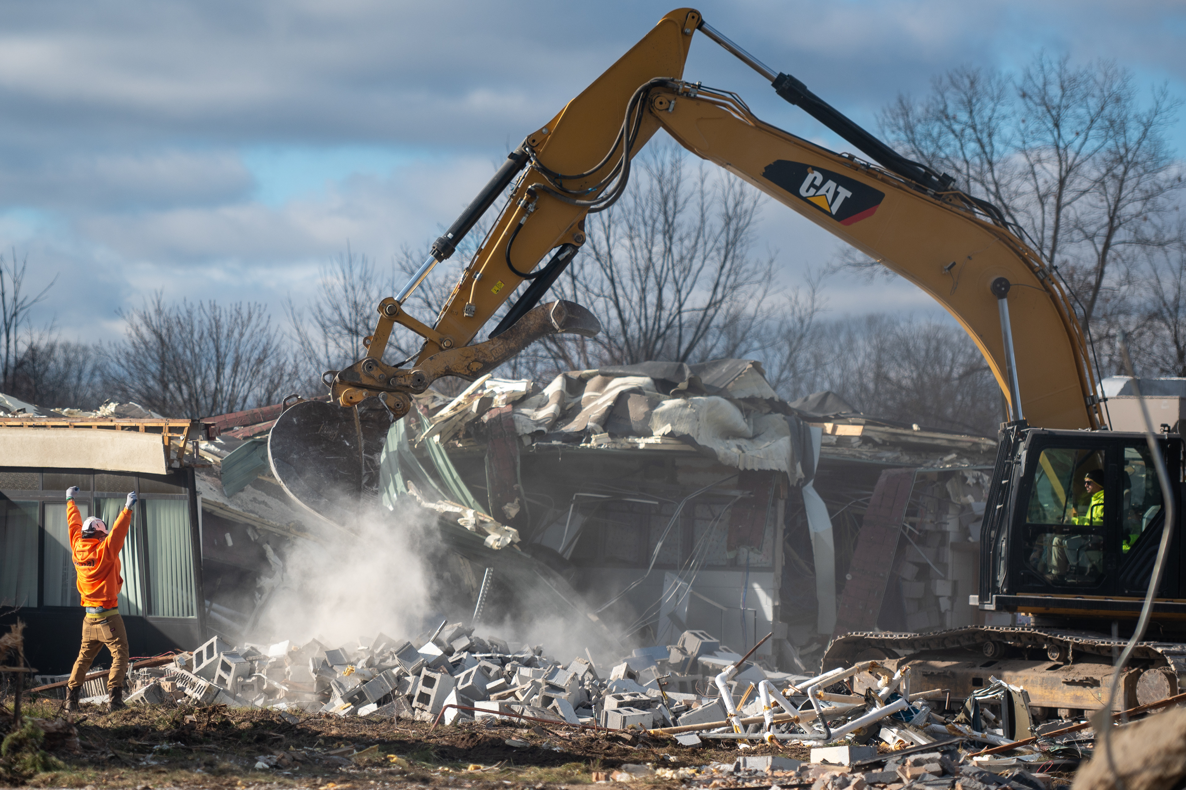 A construction employee of AUCH Construction does a cheering motion as they tear down West Bloomfield School District's Sheiko Elementary School on Tuesday, December 3, 2024. 