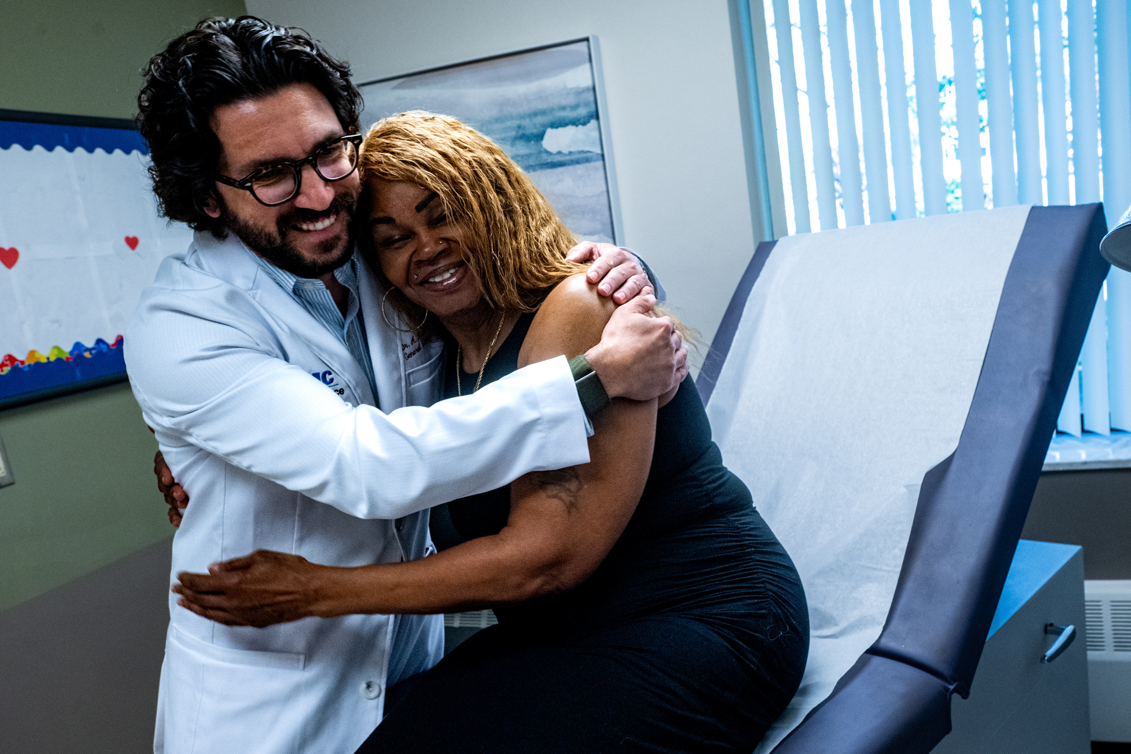 Dr. Alexander Marinica of the Detroit Medical Center embraces Toni Wilson, 65, of Warren, Mich., during a follow-up visit on Friday, May 8, 2026 after Wilson underwent lipoma surgery in May 2025 at DMC Sinai-Grace Hospital in Detroit.