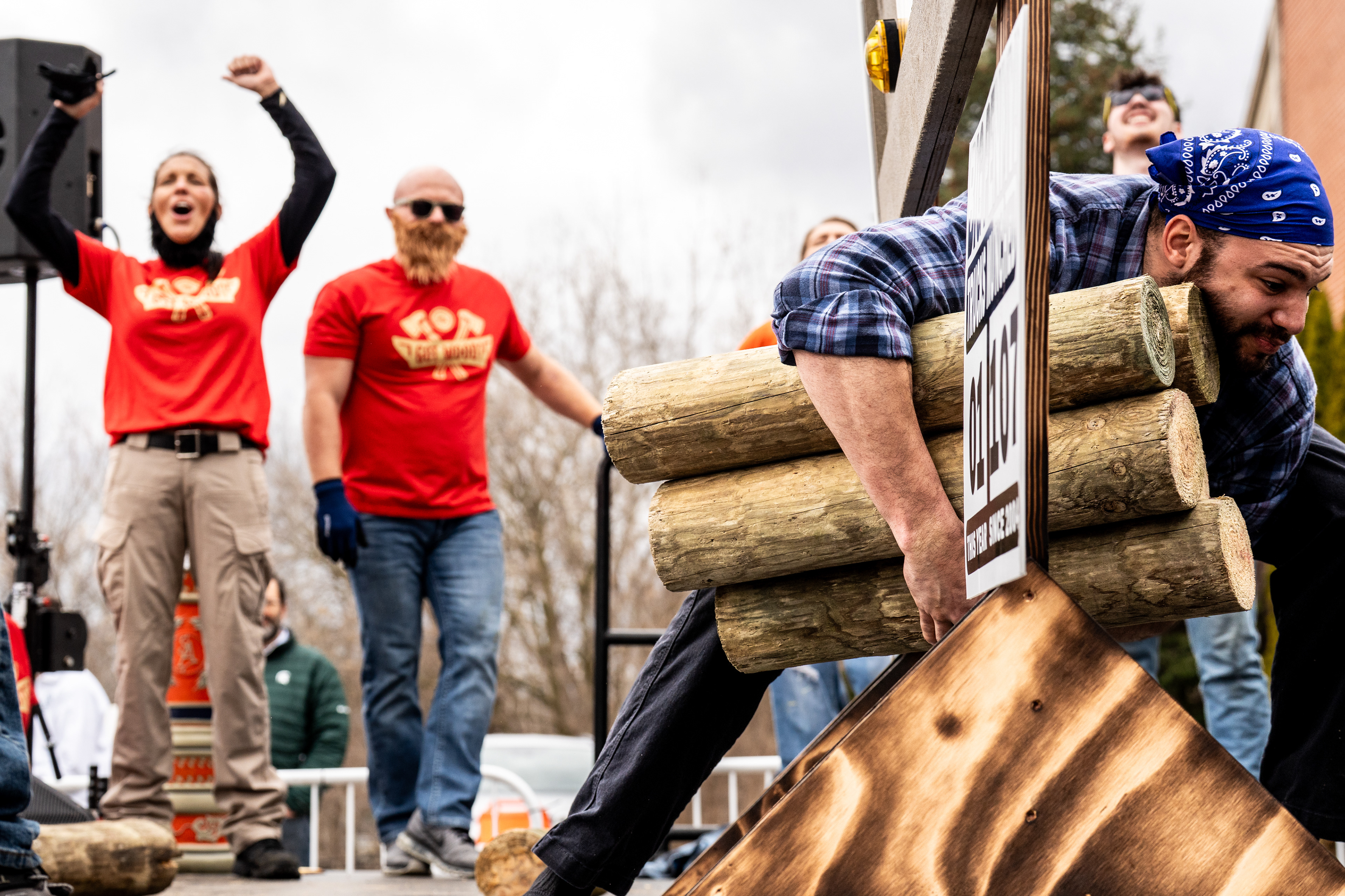 Contestants compete in a penny limbo game during the annual Brrs, Beards & Brews: A Lumberjack Festival in Old Town Lansing, Mich., on Saturday, March 7, 2026.