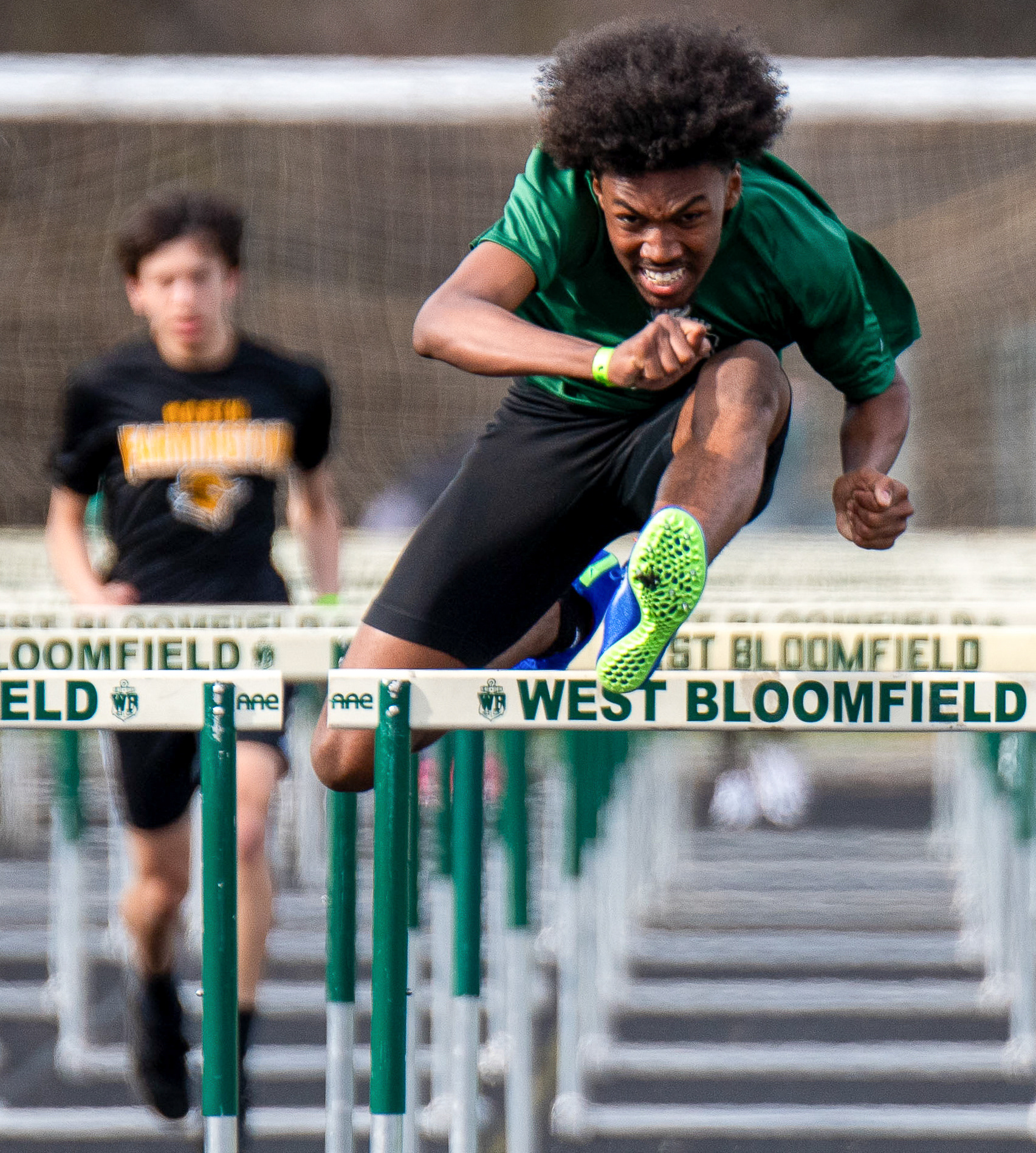 Junior Angelo Finnie leaps over hurdles in the 100-meter hurdles during a track meet against North Farmington High School at West Bloomfield High School on Wednesday, April 10, 2024.