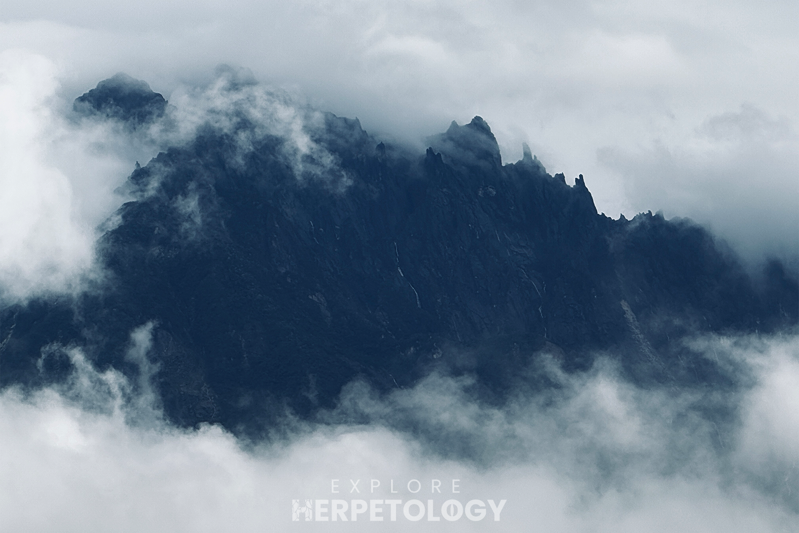 The peaks Mount Kinabalu half-shrouded in cloud.